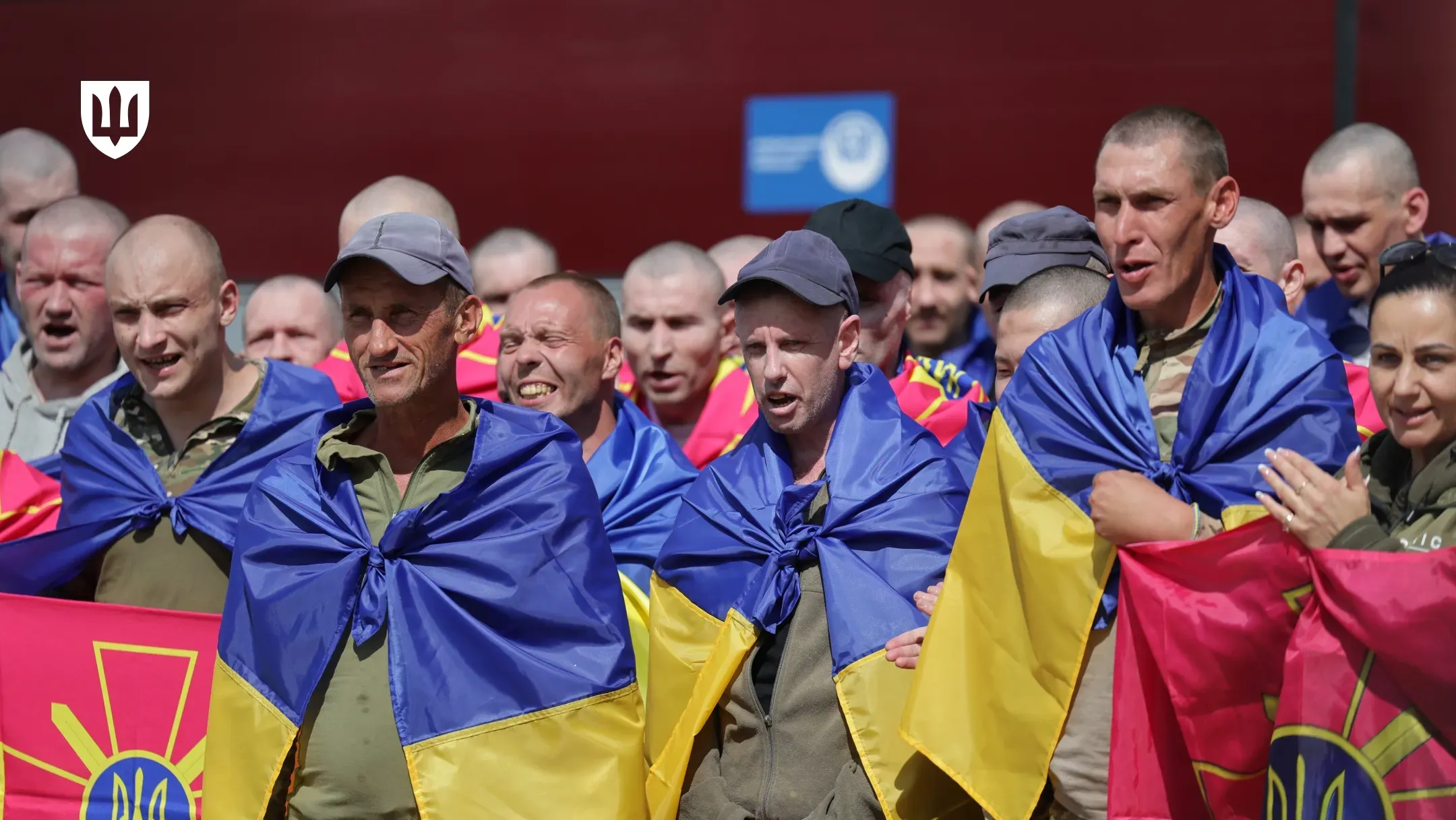 Звільнені з полону українські військовослужбовці з прапорами України
