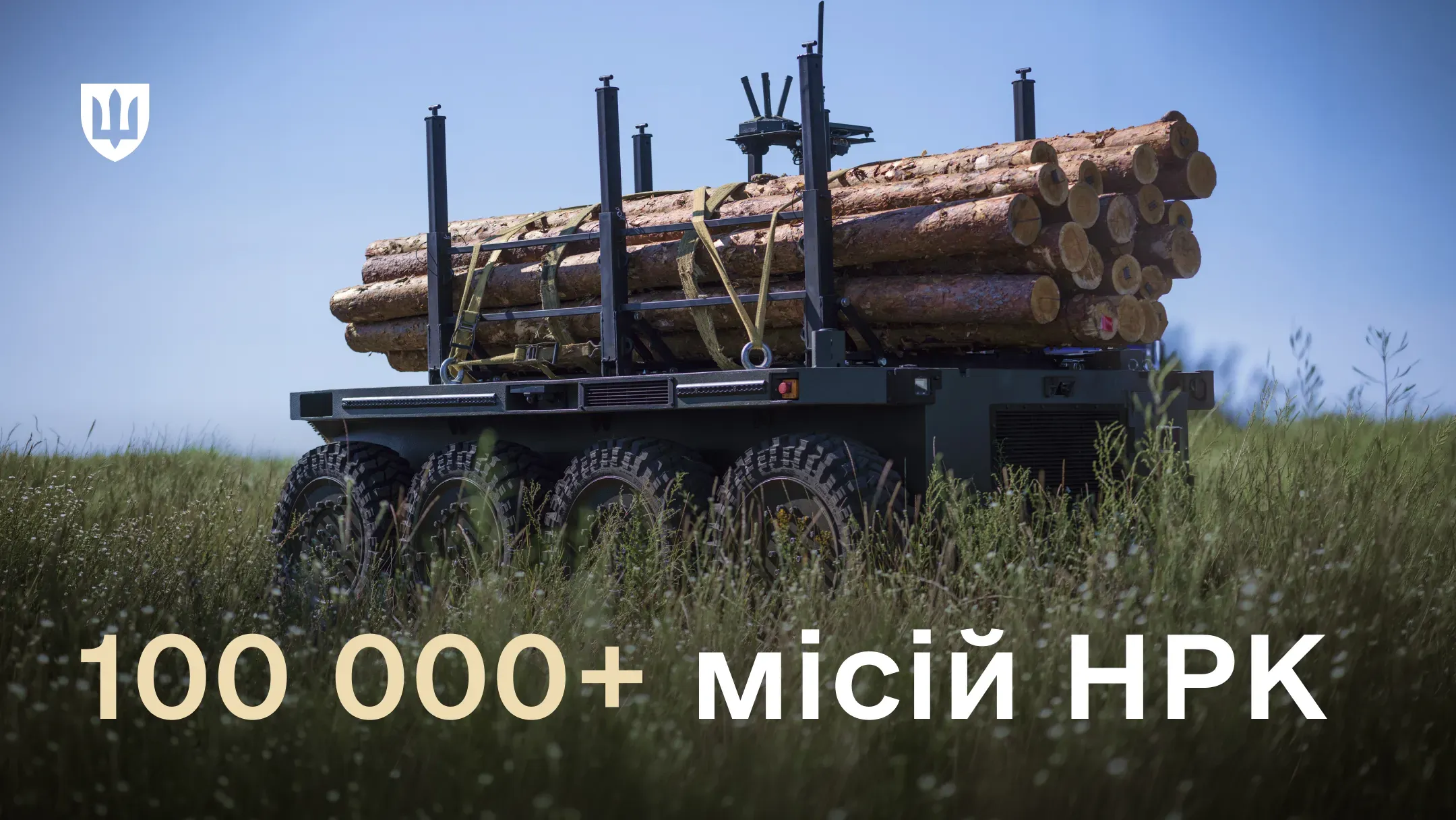 Наземний роботизований комплекс із завантаженими колодами у травʼянистому полі