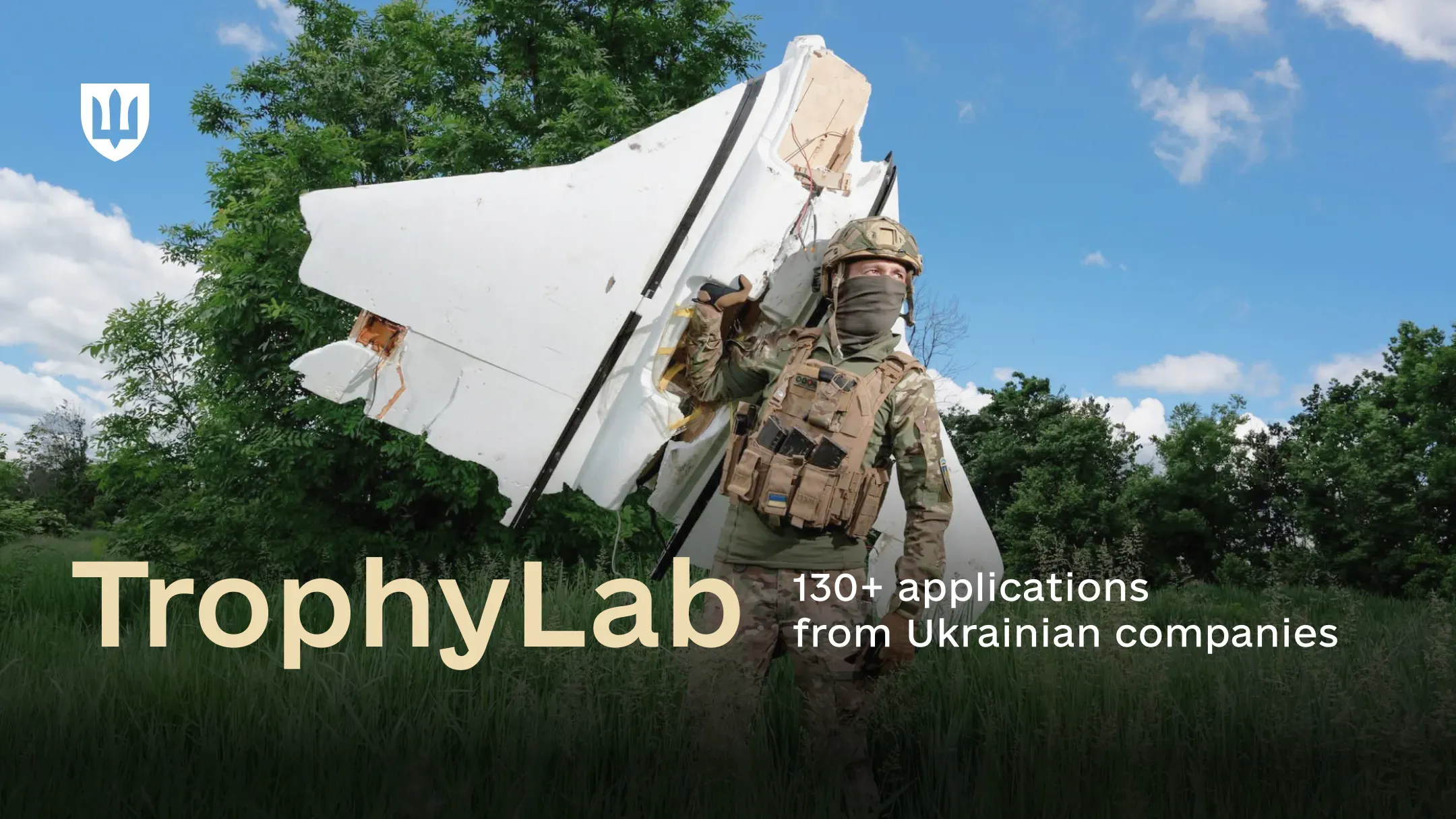 Ukrainian service member in camouflage with an enemy drone against a backdrop of trees