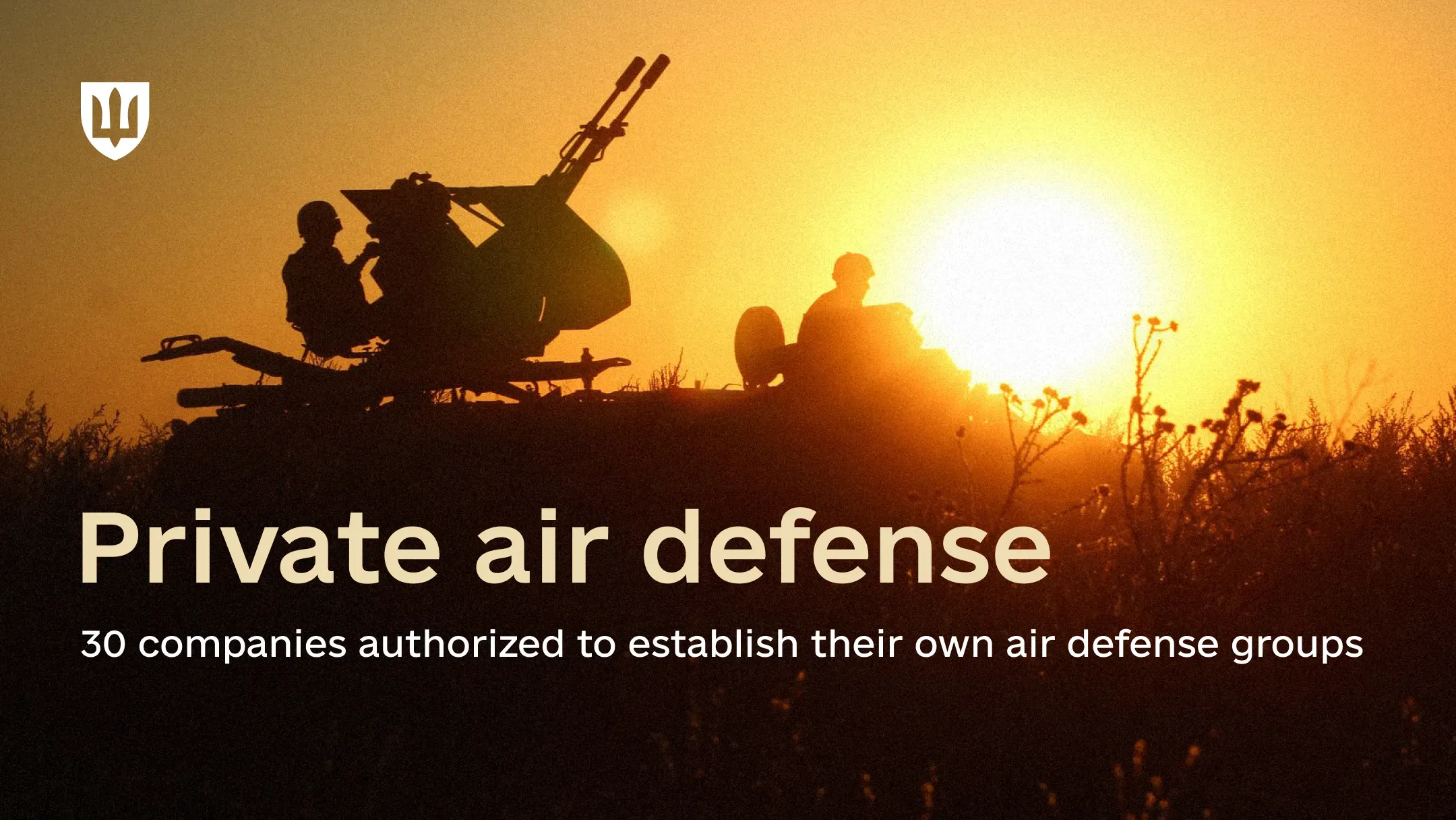 Silhouettes of people beside an air defense gun system at sunset.