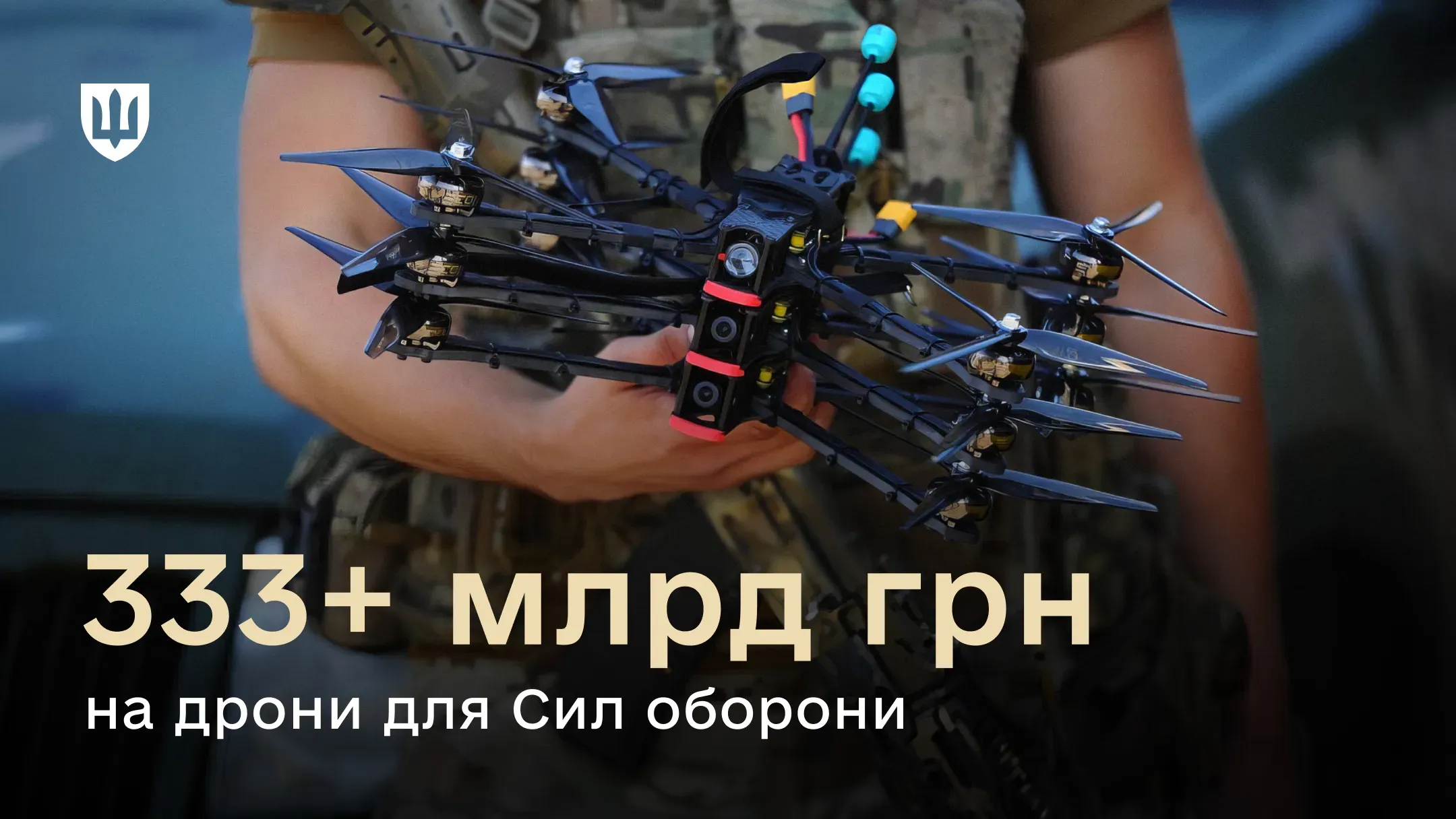 Військовий тримає в руках кілька чорних FPV-дронів