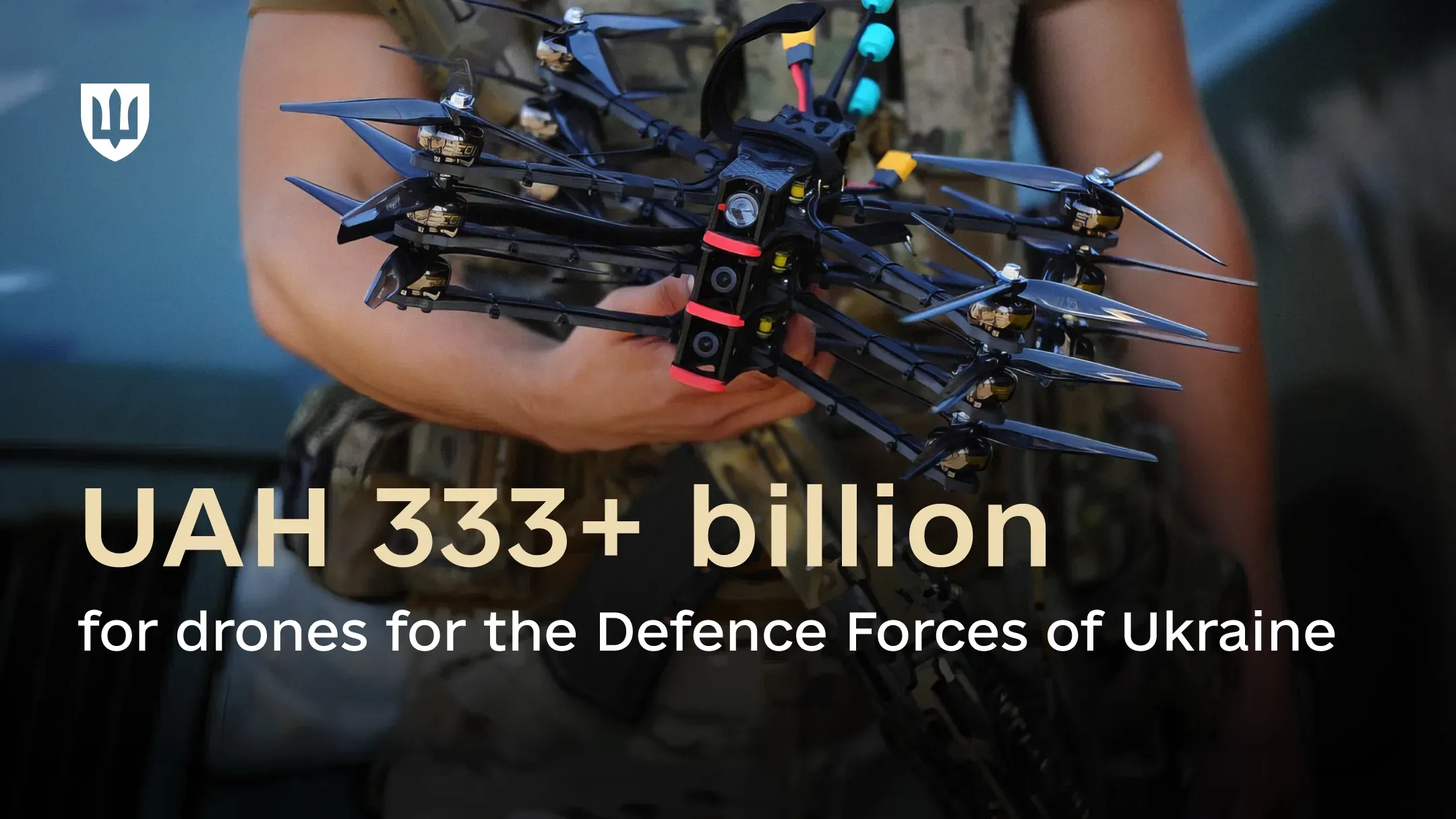 A service member holds several black FPV drones.