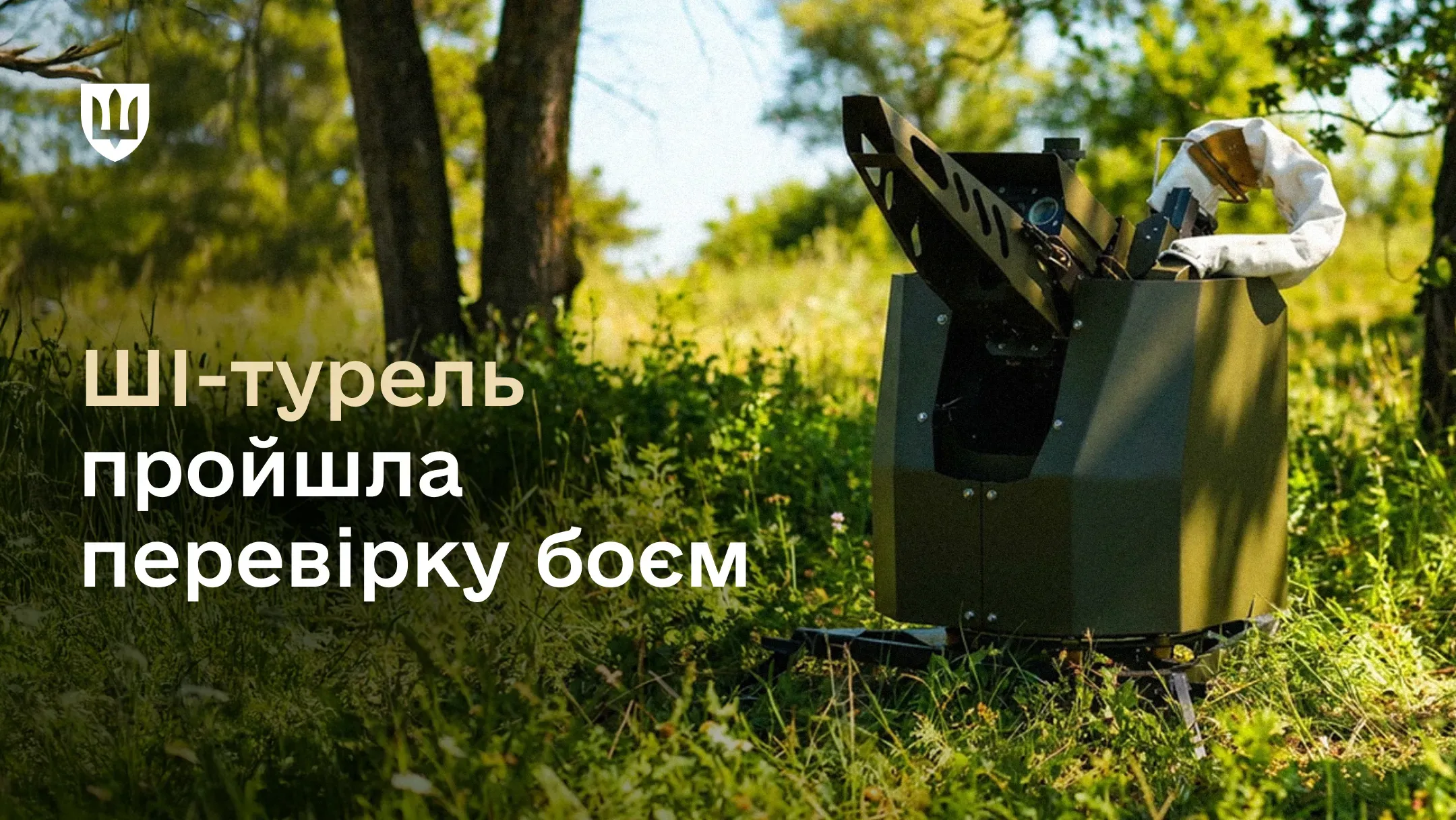 Фотографія ШІ-турелі оливкового кольору, встановленої на трав’янистій галявині серед дерев