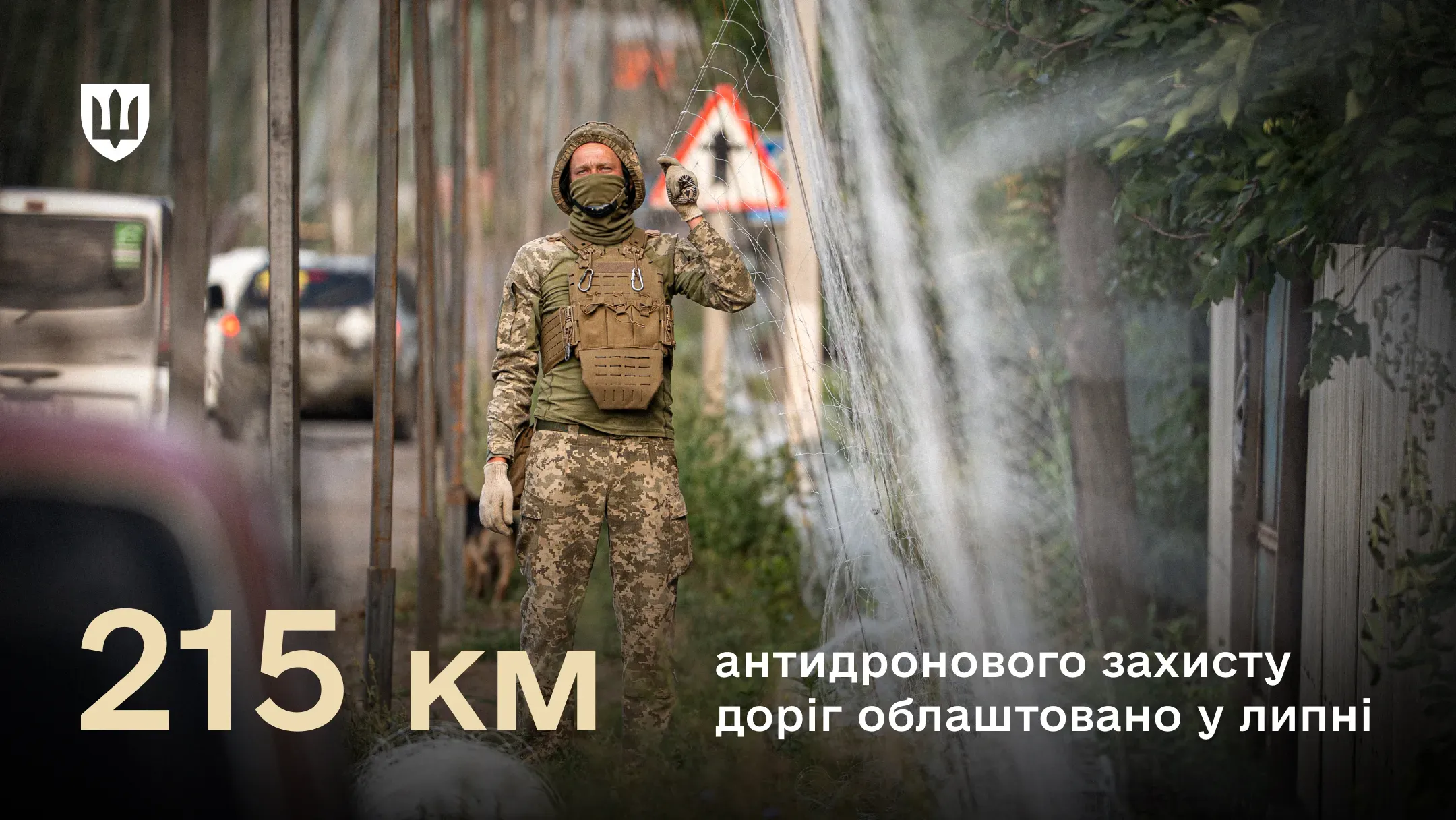 Військовий біля антидронової сітки над дорогою для протидіє fpv-дронам
