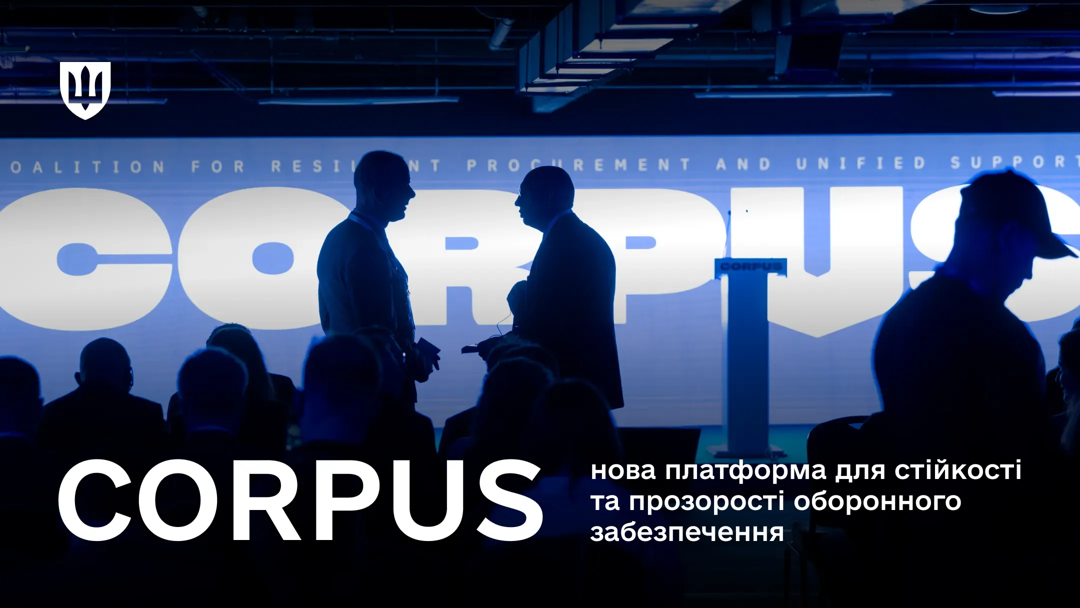 На фото силуети людей, які стоять на фоні логотипу коаліції CORPUS
