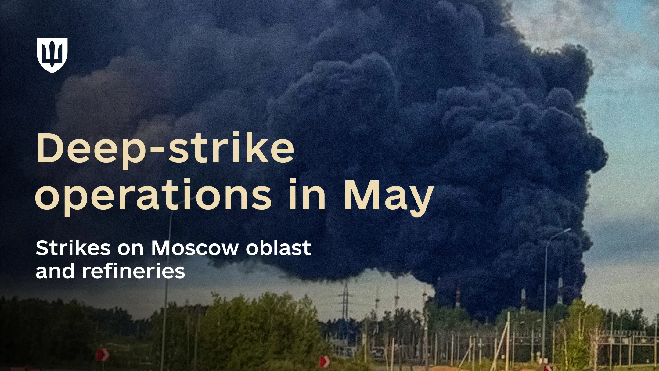 Thick plumes of black smoke rise above an industrial facility against the sky.