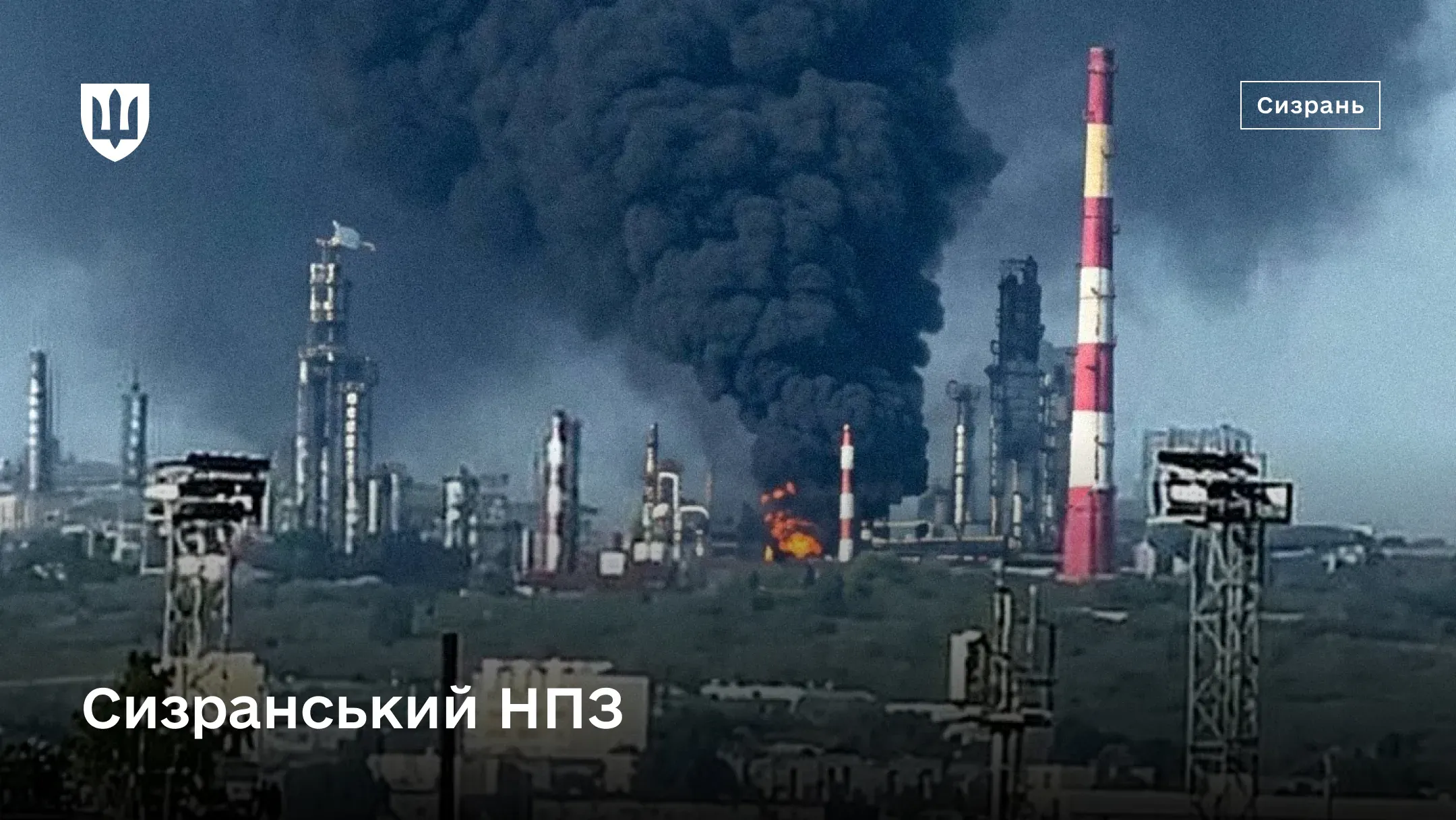 Промисловий майданчик Сизранського НПЗ  з високою червоно–білою трубою, ректифікаційними колонами, осередком вогню та величезним стовпом густого чорного диму