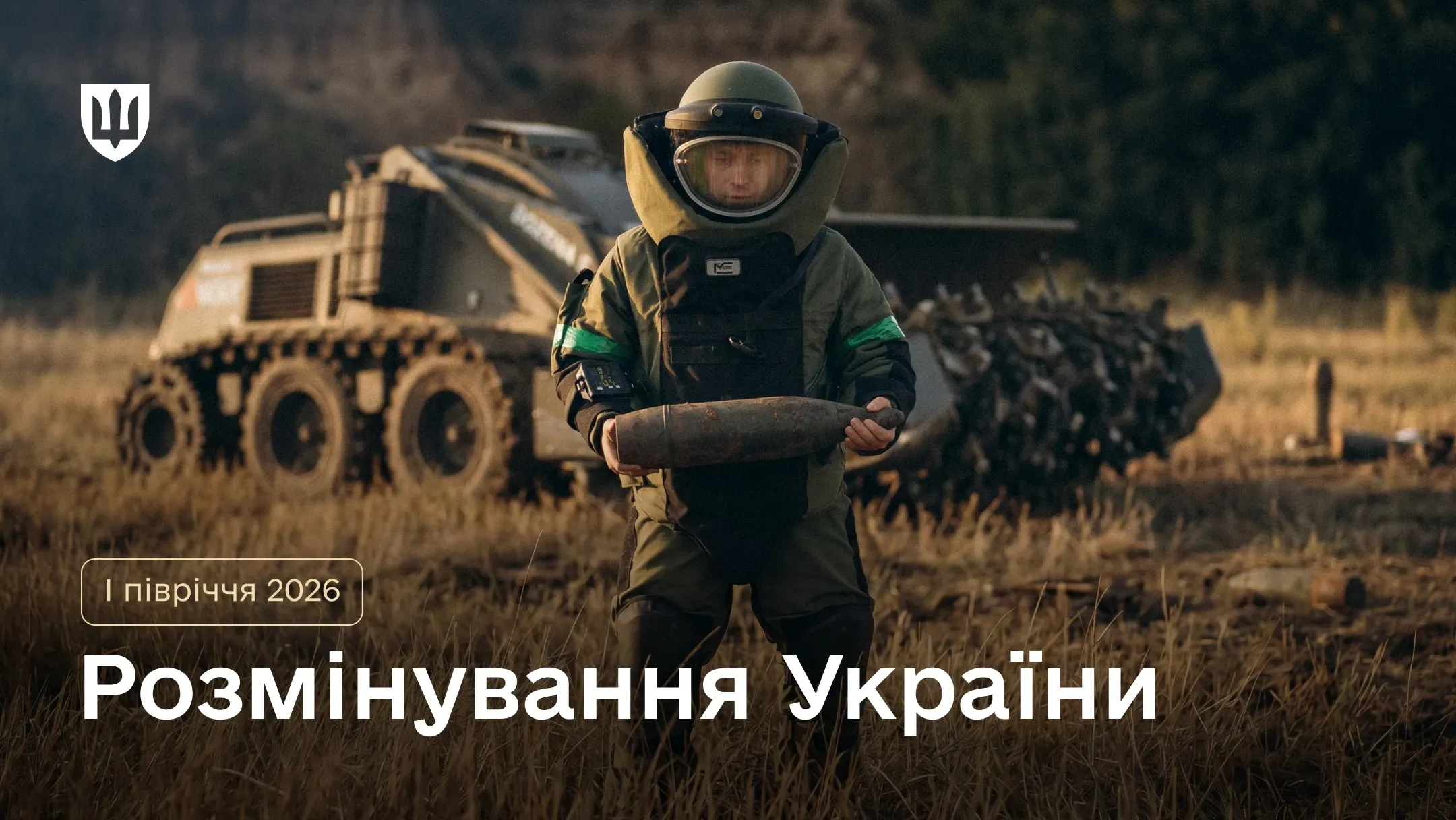 Військовий сапер тримає в руках снаряд, позаду робот-розмінувальник