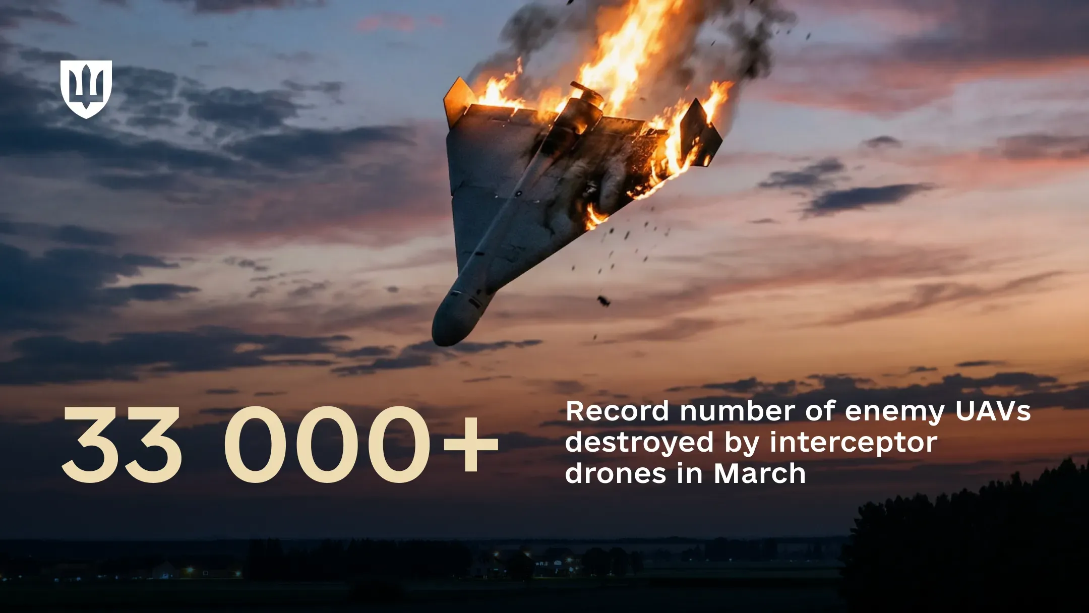 A Shahed-type drone, damaged and engulfed in flames, against the evening sky