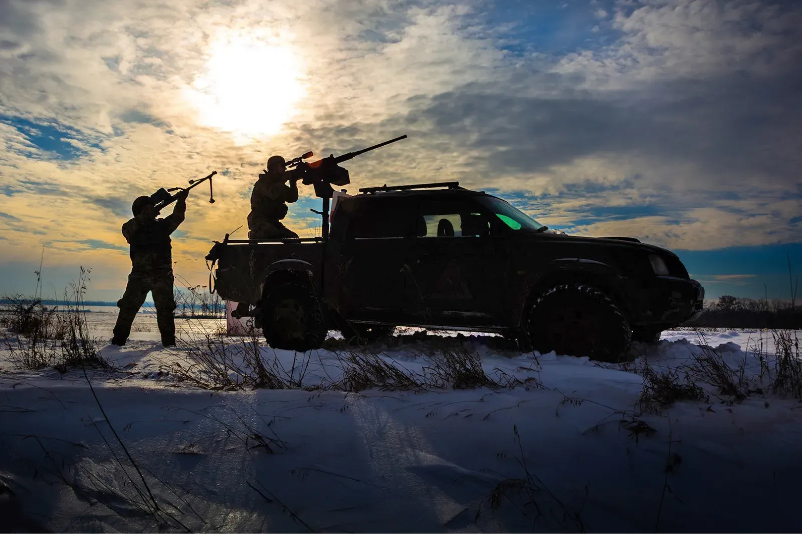 Пікап з кулеметом та українськими військовими у полі