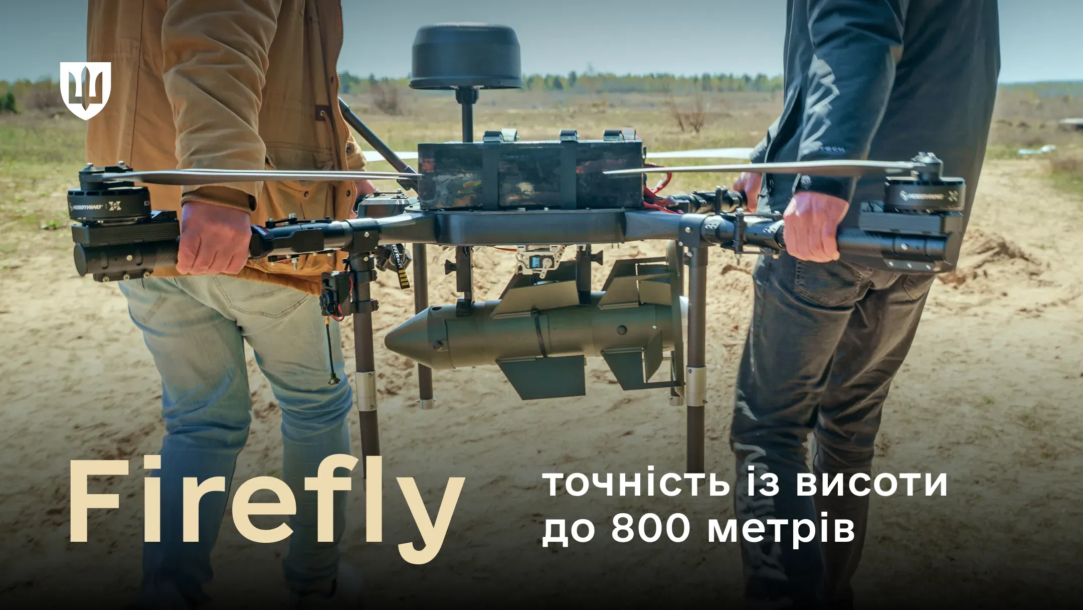 Двоє чоловіків тримають у руках великий безпілотник із підвішеним боєприпасом Firefly