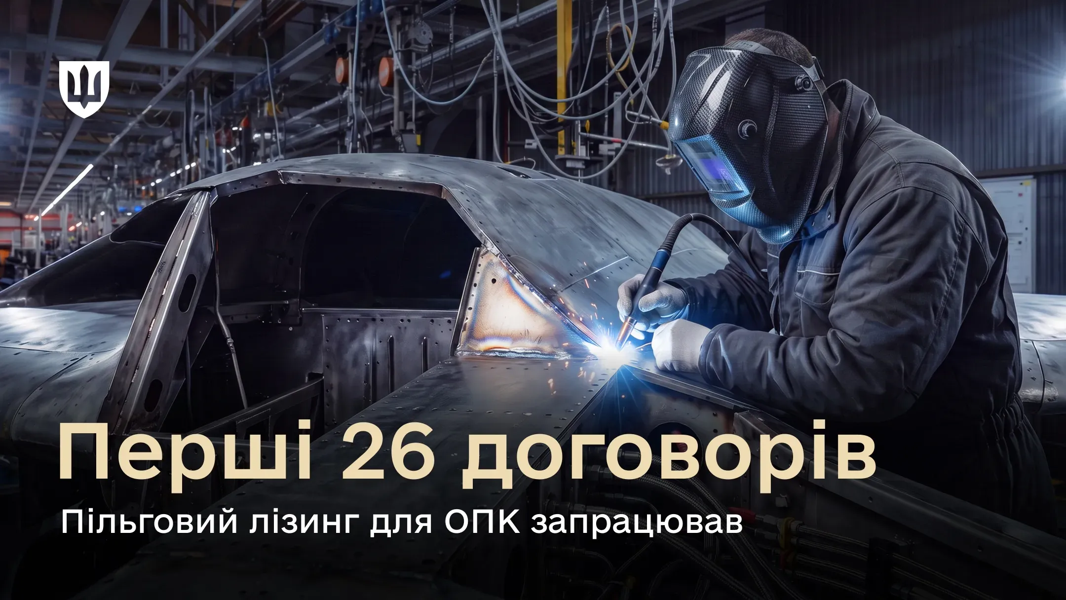 Робітник у захисній масці та рукавичках виконує зварювальні роботи на металевій конструкції у виробничому цеху