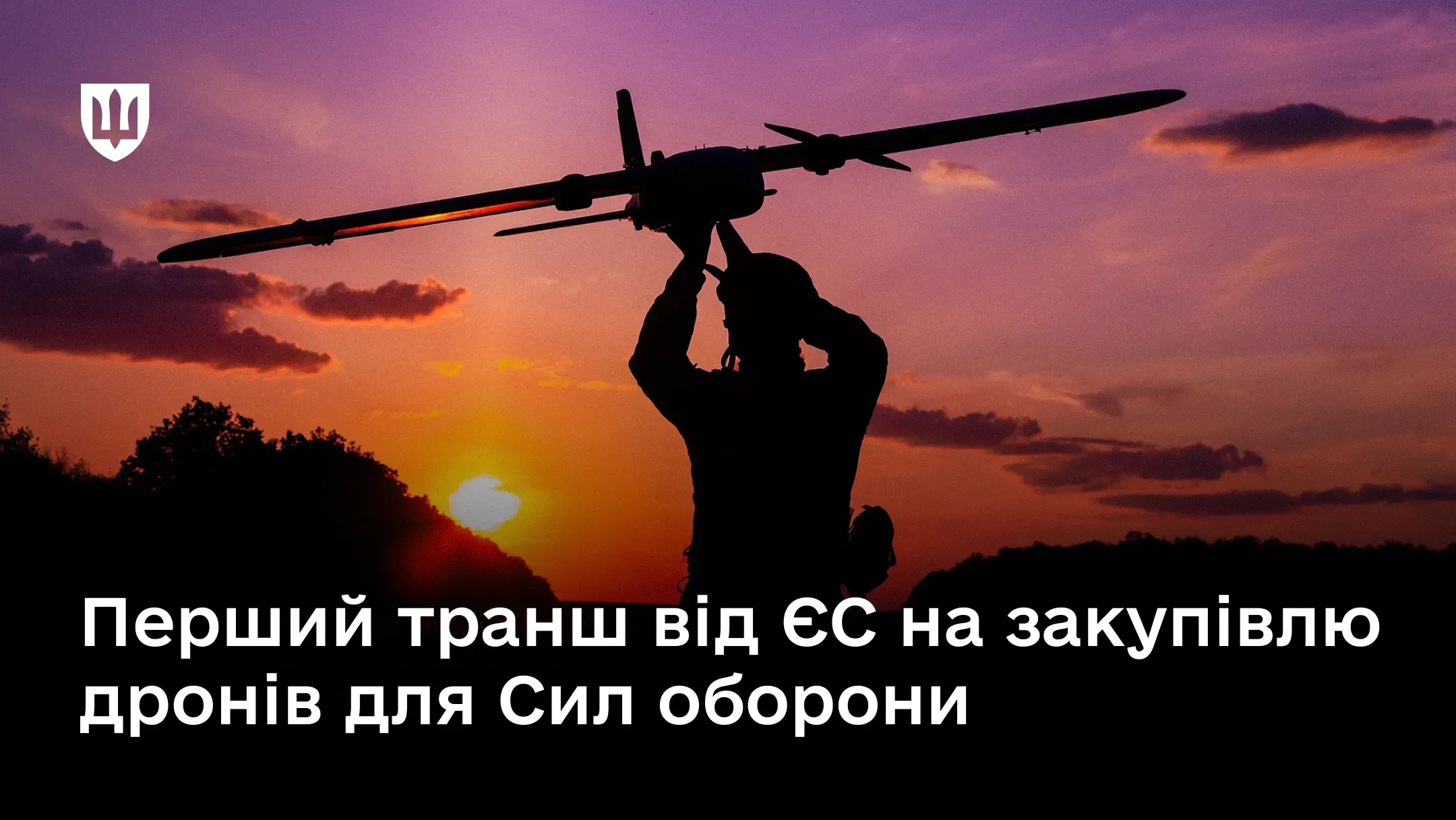 На зображенні показано силует військового, який тримає безпілотник на тлі вечірнього сонця