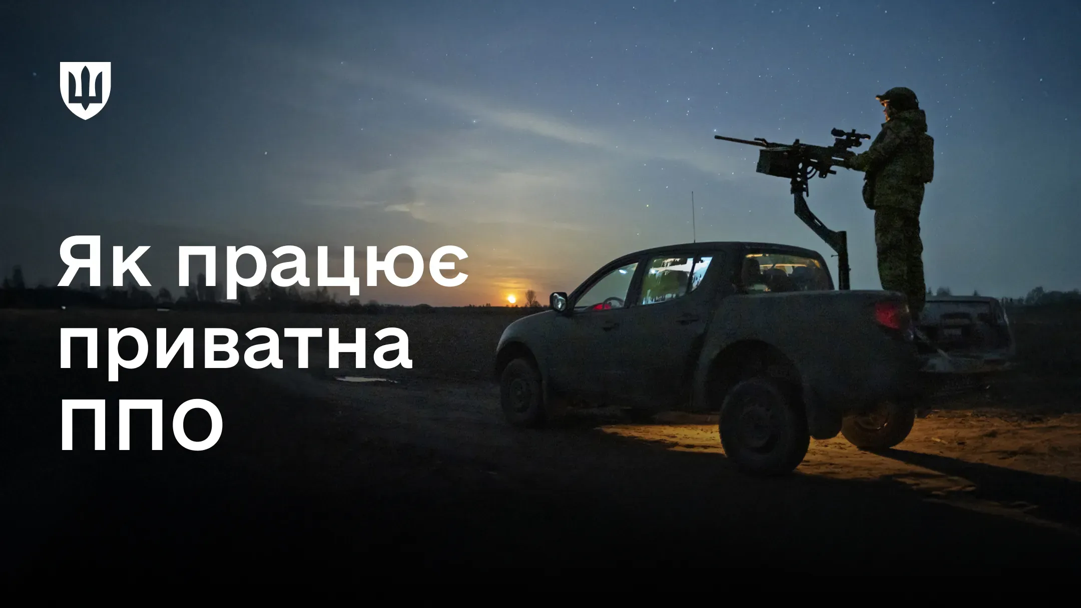 Чоловік стоїть у кузові пікапа з кулеметом на тлі нічного неба