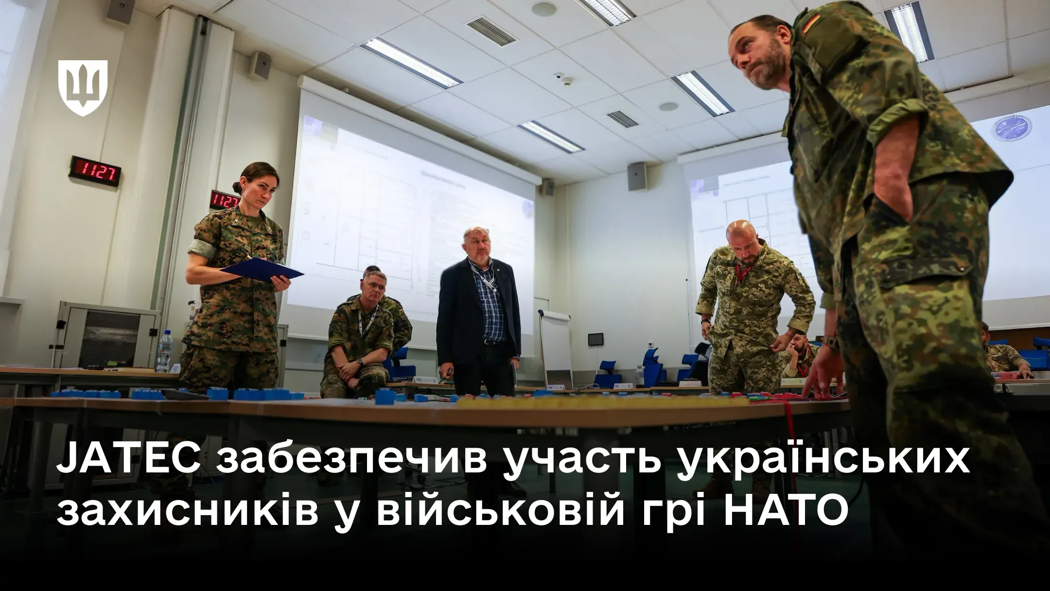 Військовослужбовці та цивільні фахівці працюють за столами у навчальній аудиторії під час військової гри