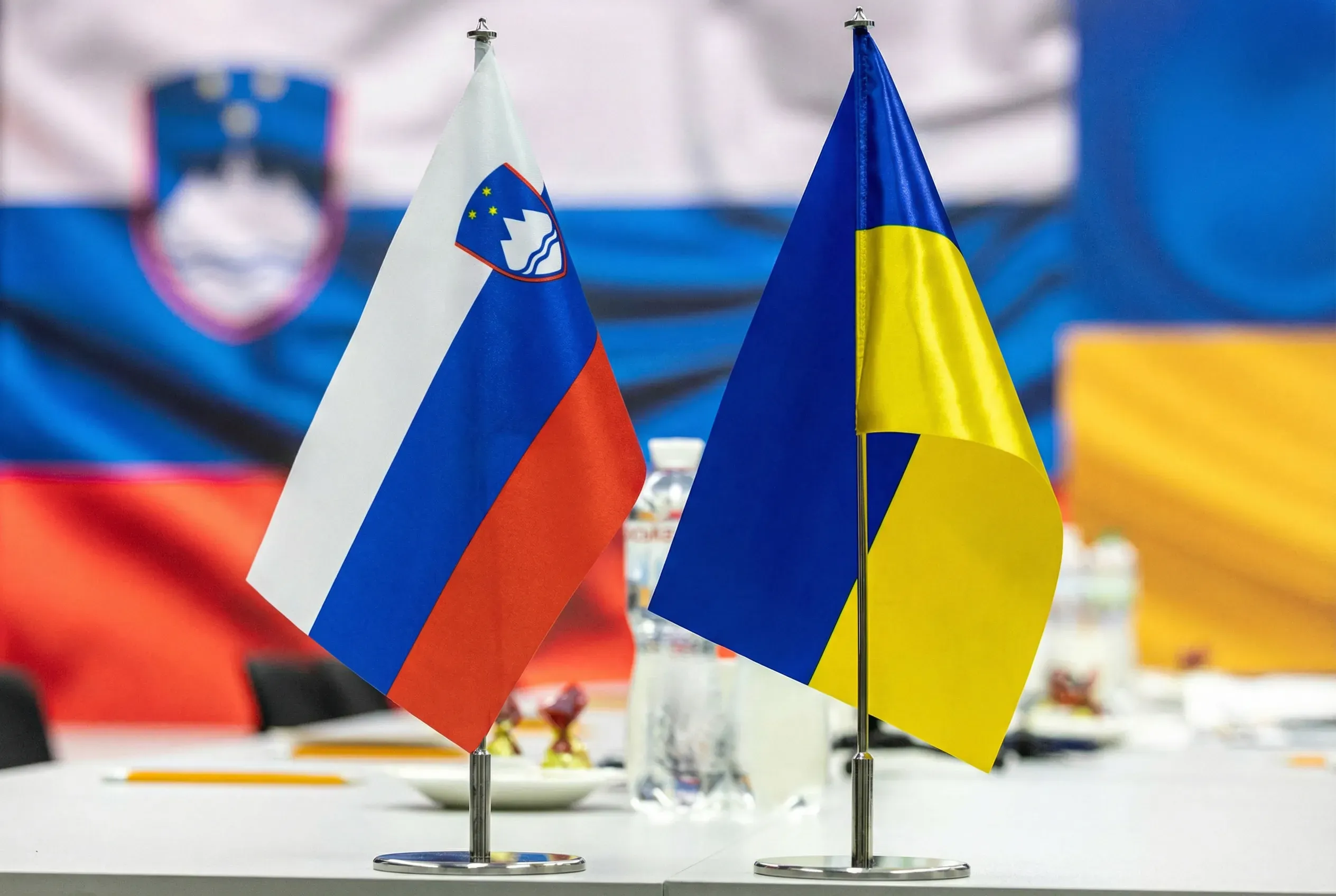 Flags of Ukraine and Slovenia are placed on a table during talks between the delegations