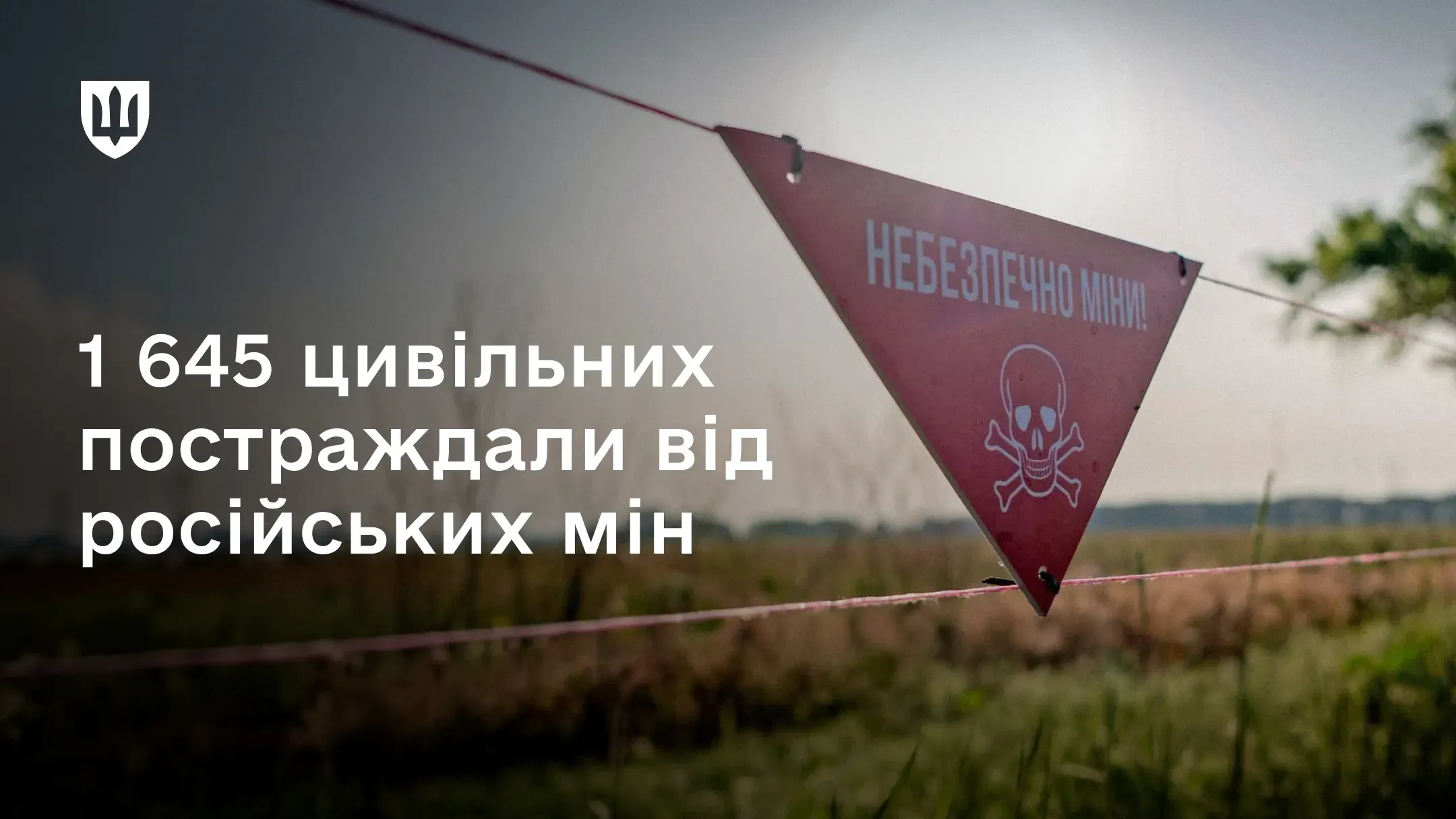 Червоний попереджувальний знак мінної небезпеки на огорожі у полі,