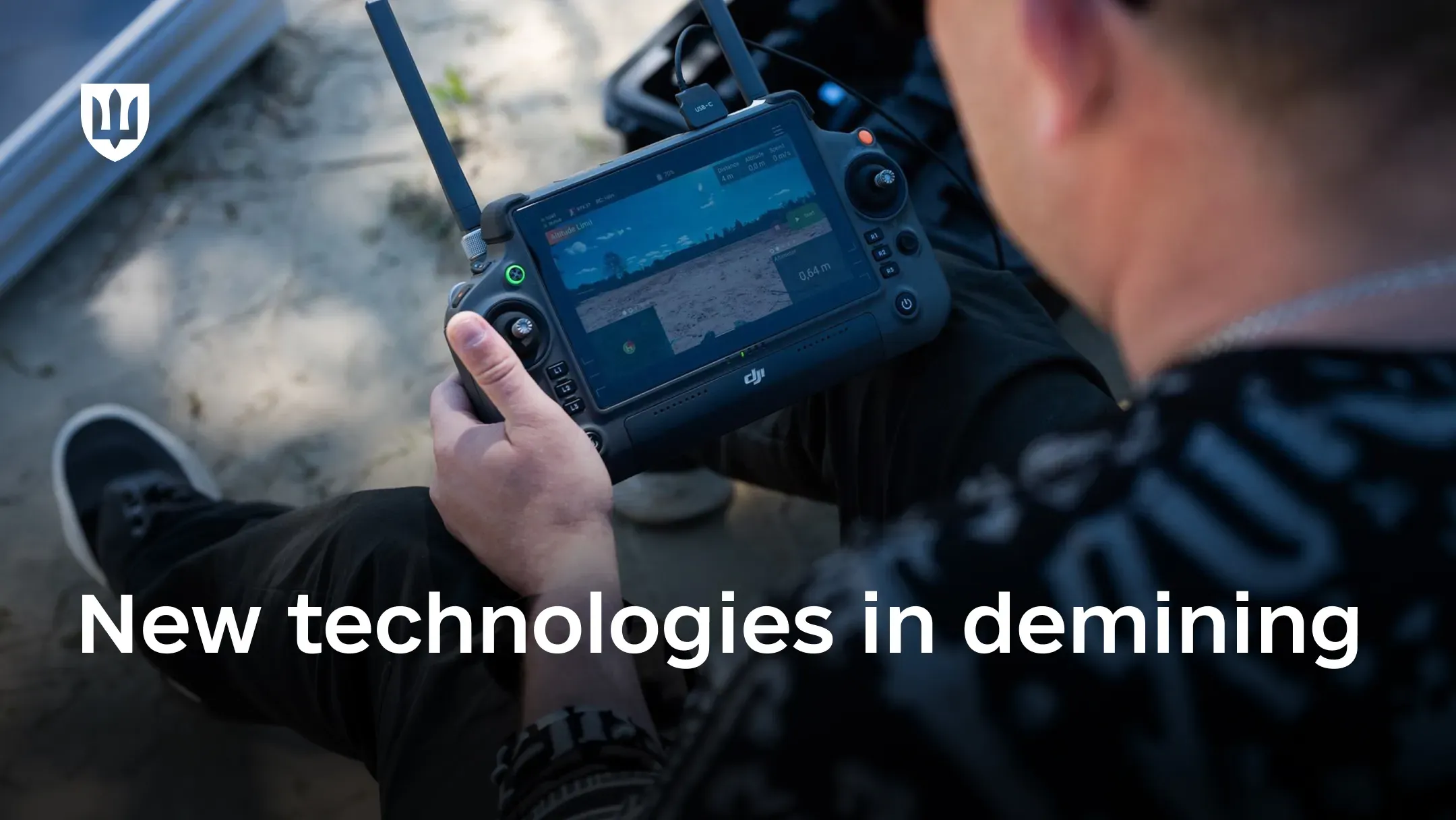 A UAV operator using a remote control system to monitor terrain through an onboard display