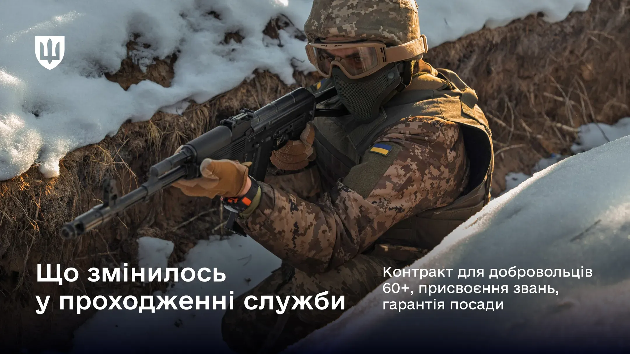 Український військовослужбовець у повному екіпіруванні тримає автомат у засніженому окопі