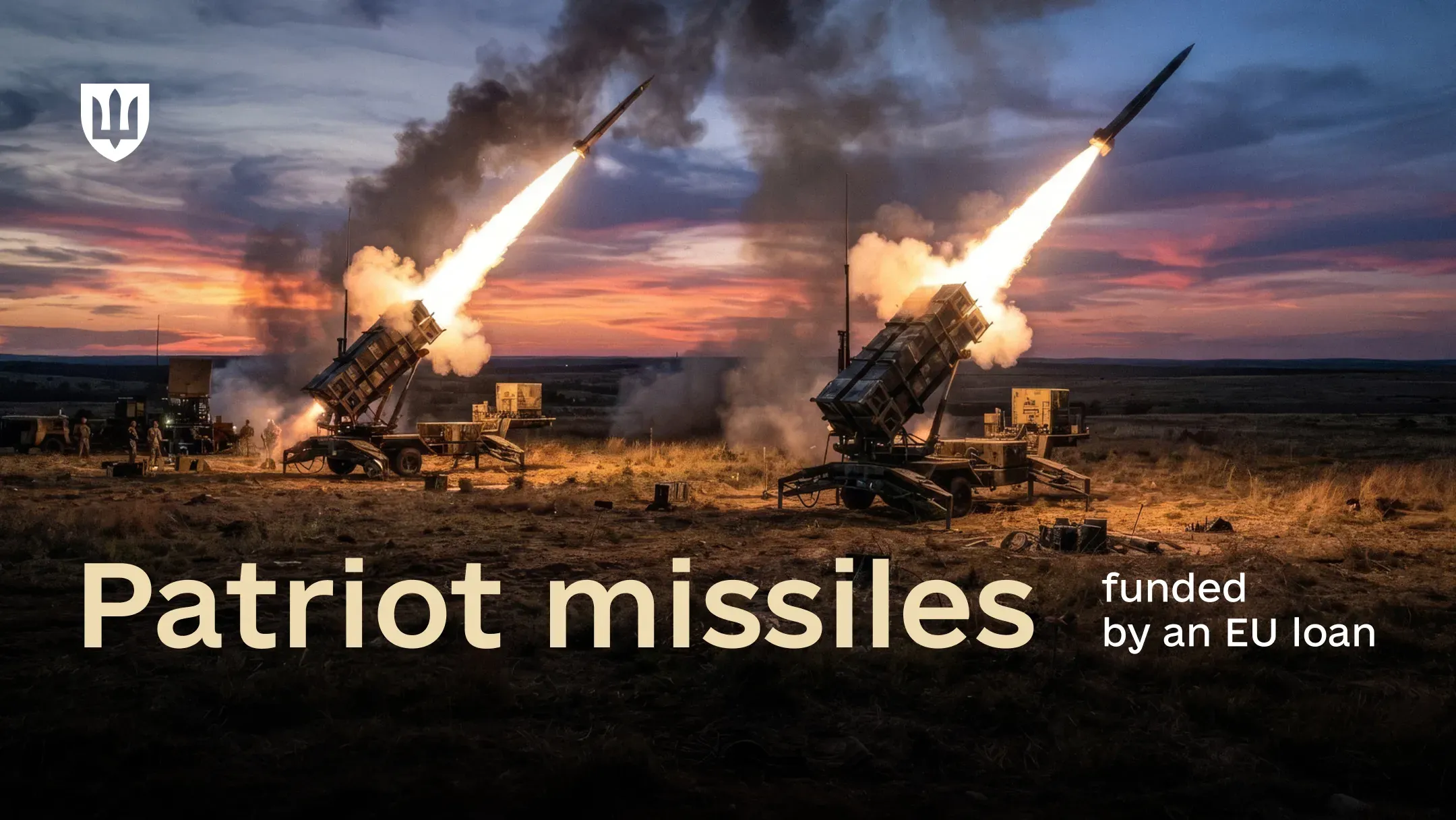 Two Patriot surface-to-air missile launchers firing missiles in a field against an evening sky