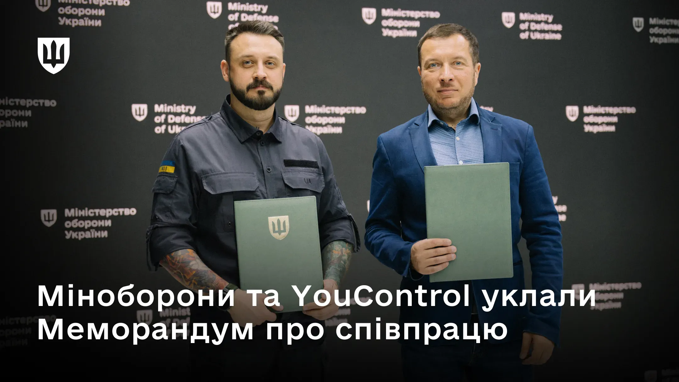 Мстислав Банік і Данило Глоба тримають у руках зелені папки з меморандумом про співпрацю Міноборони та YouControl