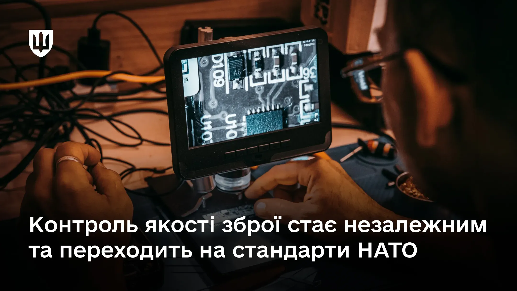 Фахівець працює з електронним компонентом під цифровим мікроскопом. На екрані збільшене зображення друкованої плати.