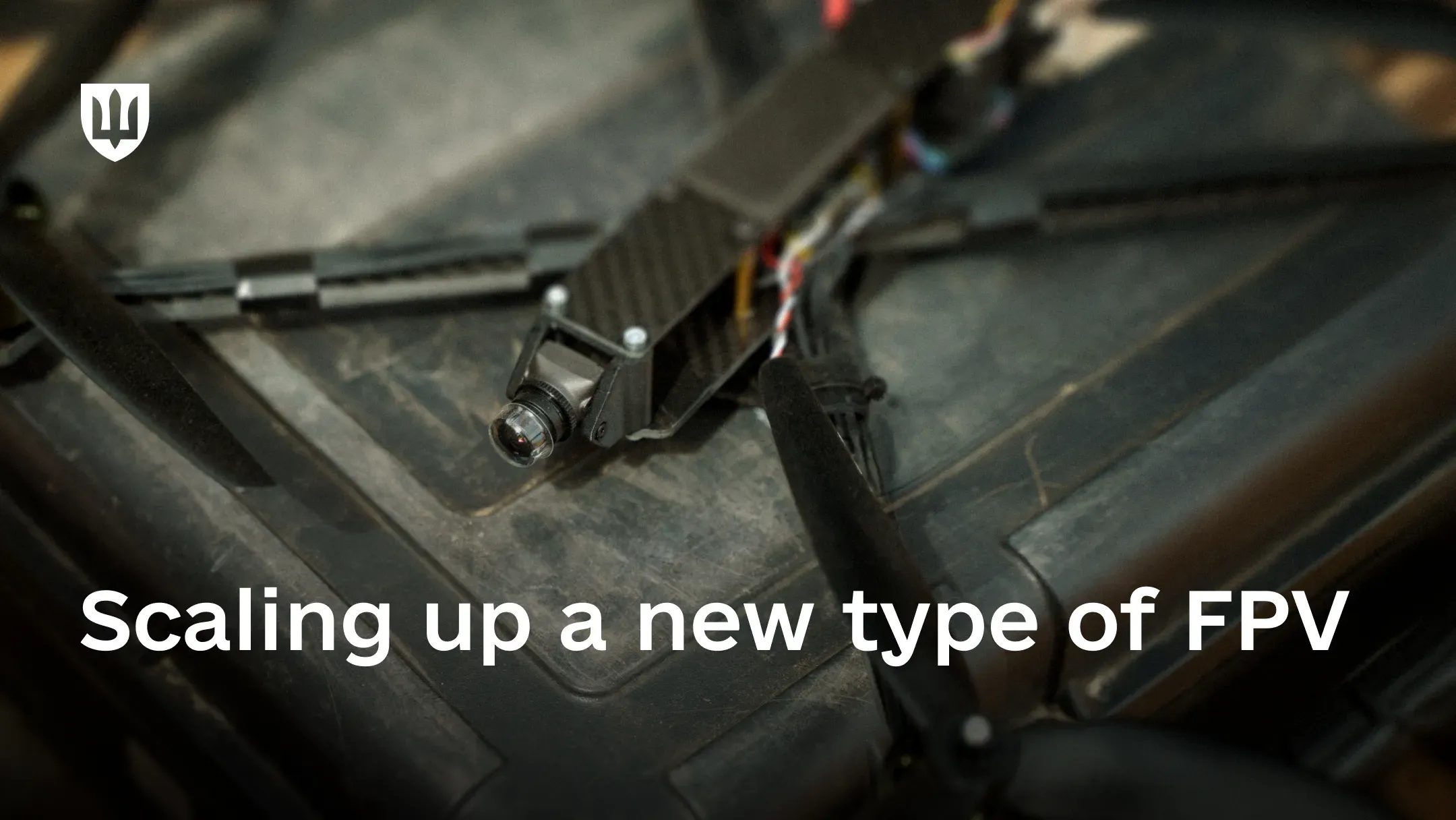 FPV drone lying on an equipment case, with the text “Scaling up a new type of FPV drones” on the image