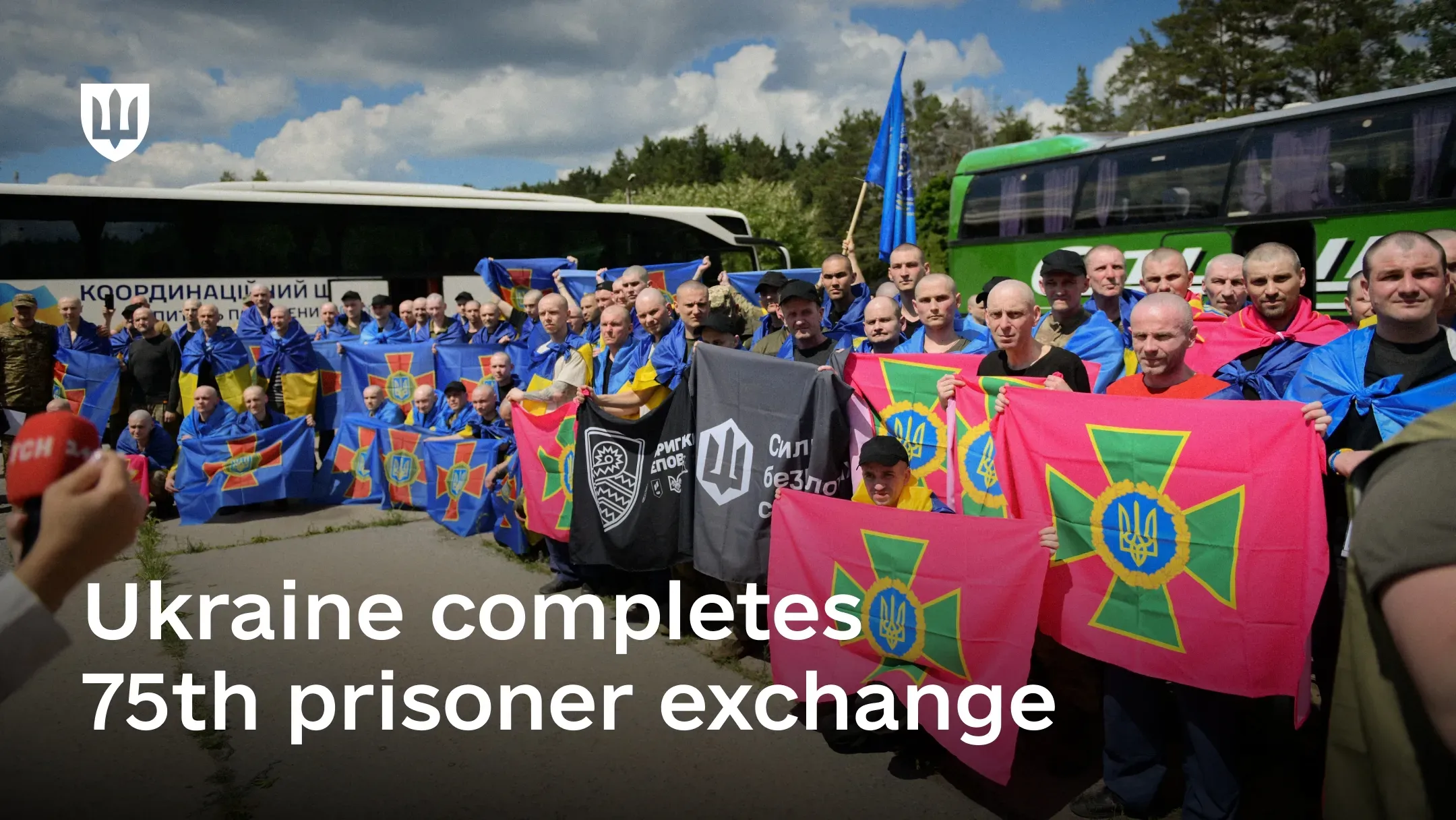 A group of released Ukrainian service members holding service flags during Ukraine’s 75th prisoner exchange