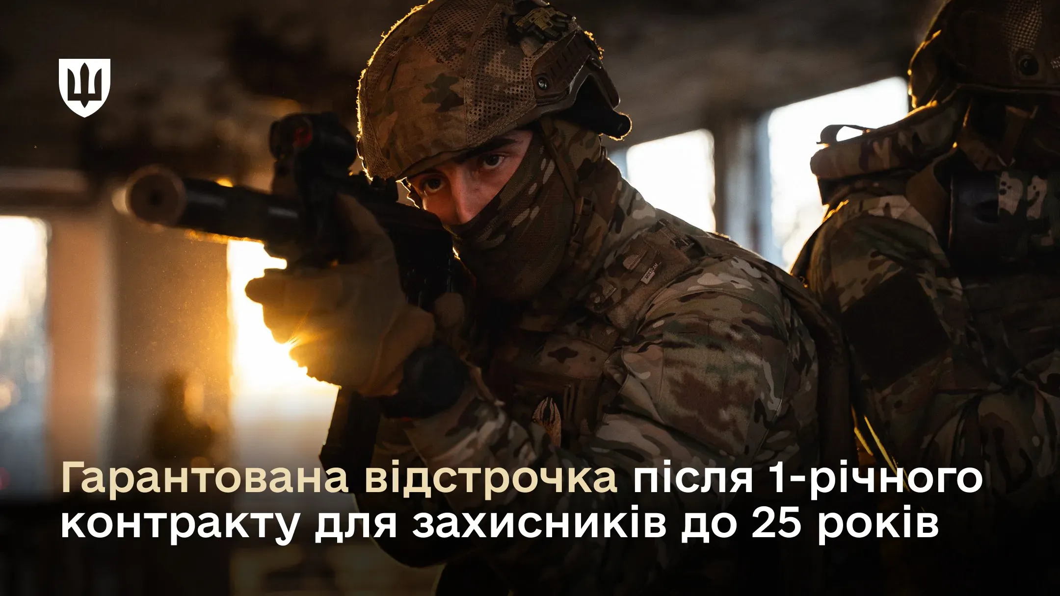 Фото двох українських військовослужбовців у тактичному спорядженні та мультикамі всередині пошкодженої боєм будівлі. Солдат на передньому плані цілиться з гвинтівки, його обличчя в балаклаві.