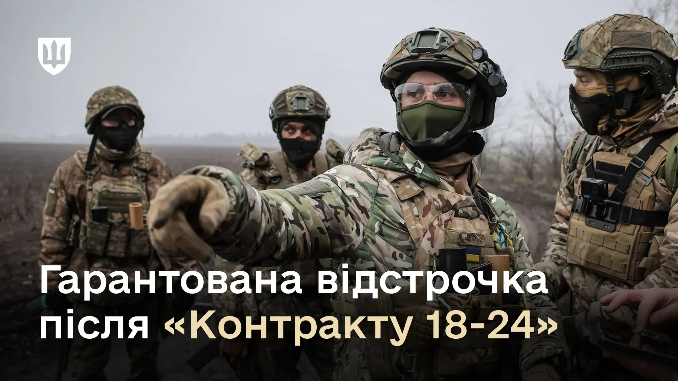 Група з чотирьох українських військовослужбовців у повному бойовому спорядженні на відкритій місцевості в похмуру погоду