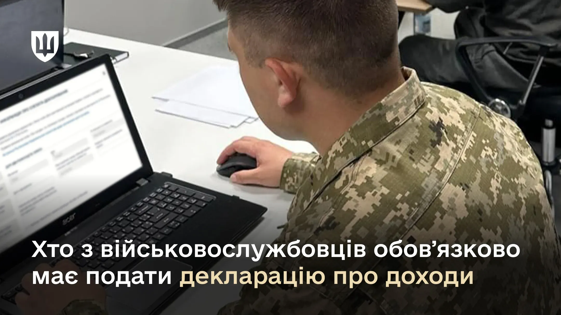 Військовослужбовець у піксельній формі заповнює декларацію у ноутбуці, сидячи за столом