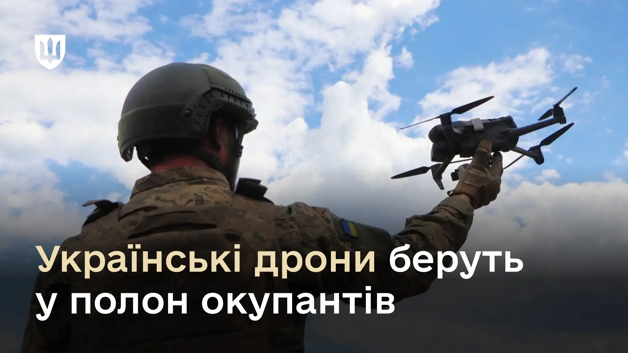Український військовий у камуфляжі та шоломі тримає в руці квадрокоптер на фоні хмарного неба