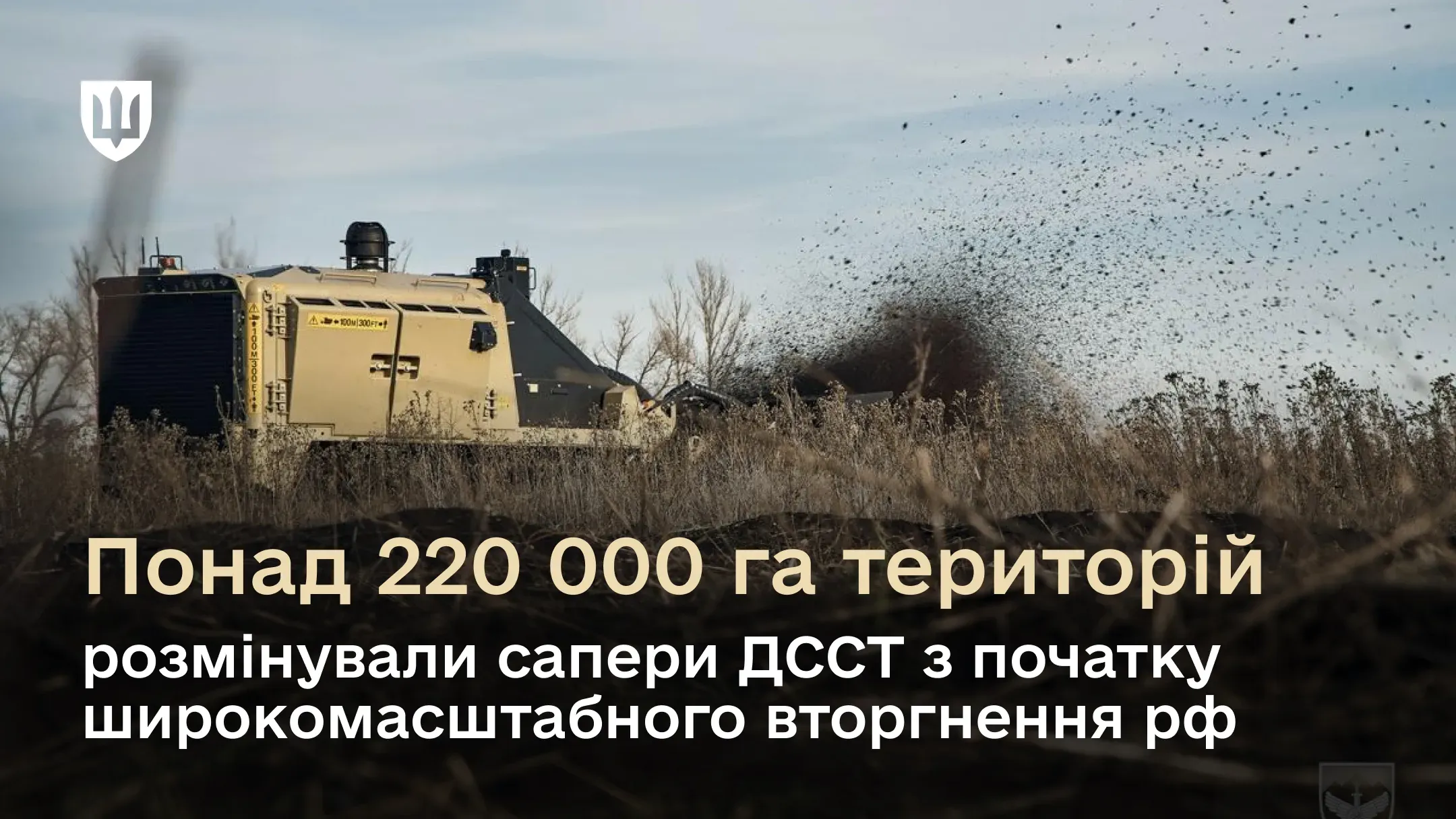 Спеціальна машина для розмінування їде по полю на тлі дерев і кущів 