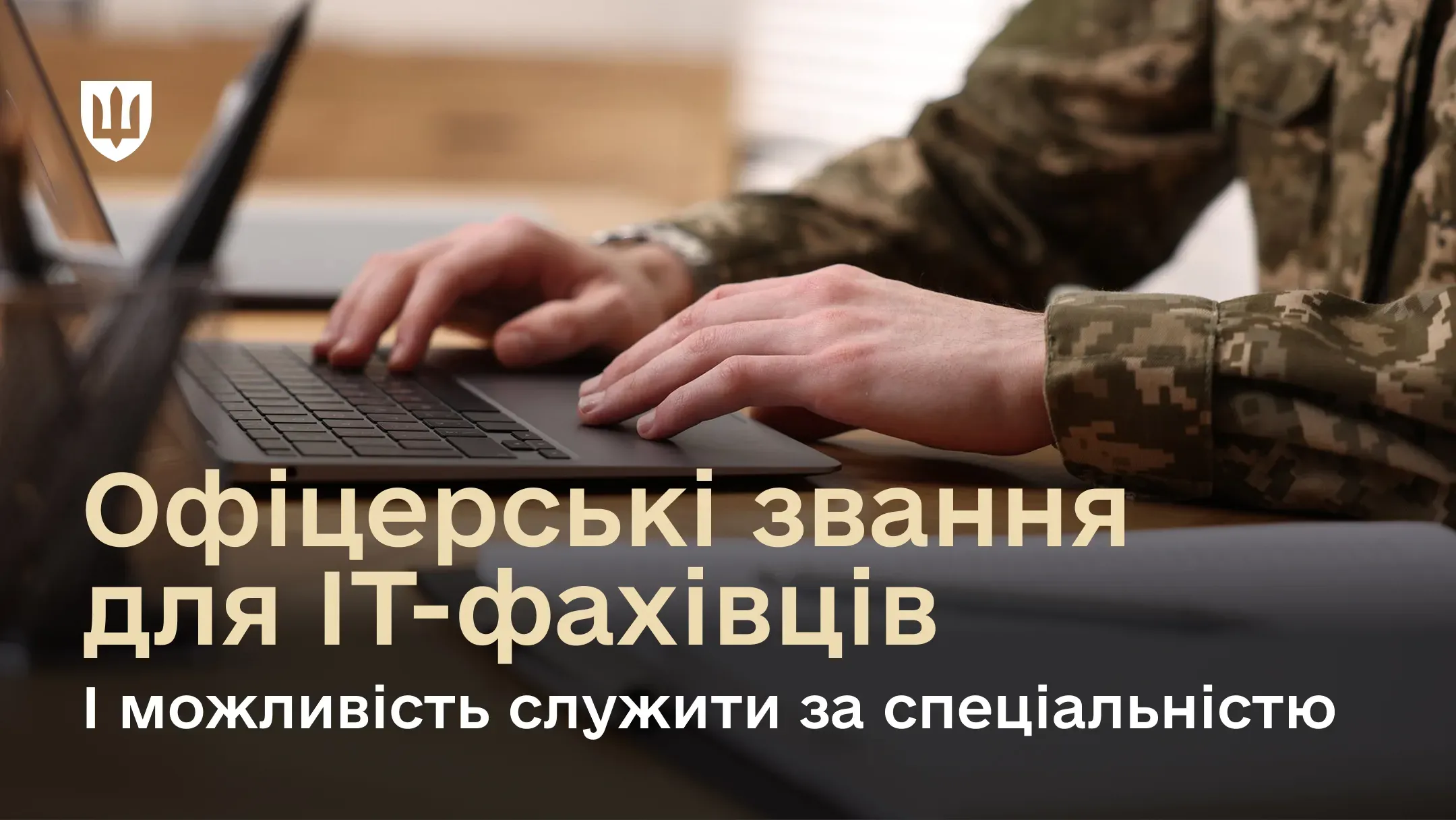 На фото – людина в українській військовій формі. Вона сидить за столом і друкує на ноутбуці. Напис інформує про можливість отримати офіцерське звання для IT-фахівців і служити за своєю спеціальністю