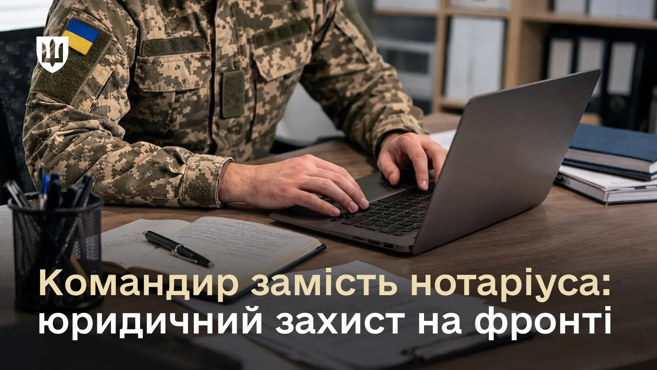 Військовослужбовець у формі працює за ноутбуком поруч із паперовими документами. На зображенні розміщено напис: «Командир замість нотаріуса: юридичний захист на фронті».