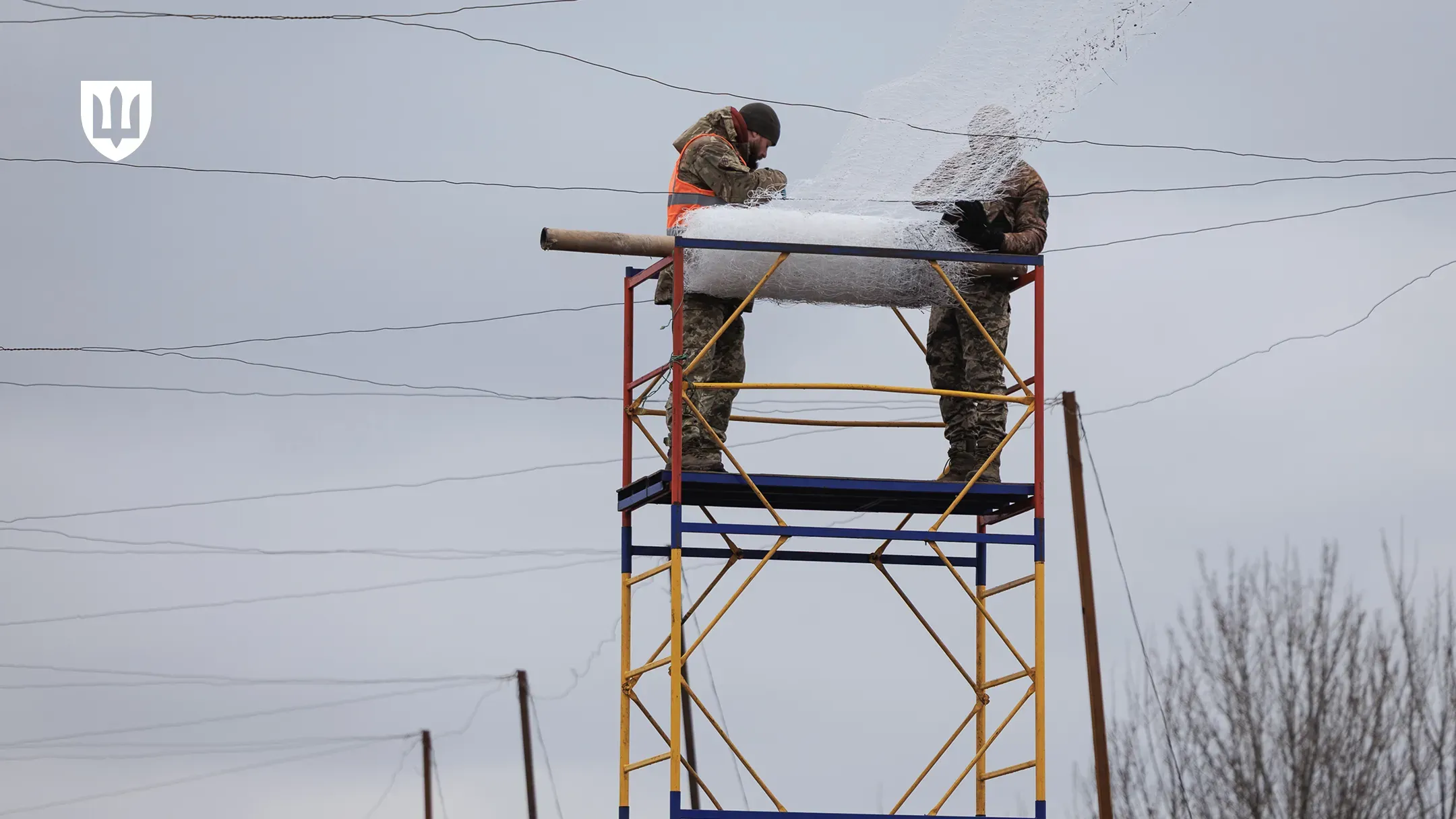 Українські військовослужбовці встановлюють антидроновий захист над дорогою