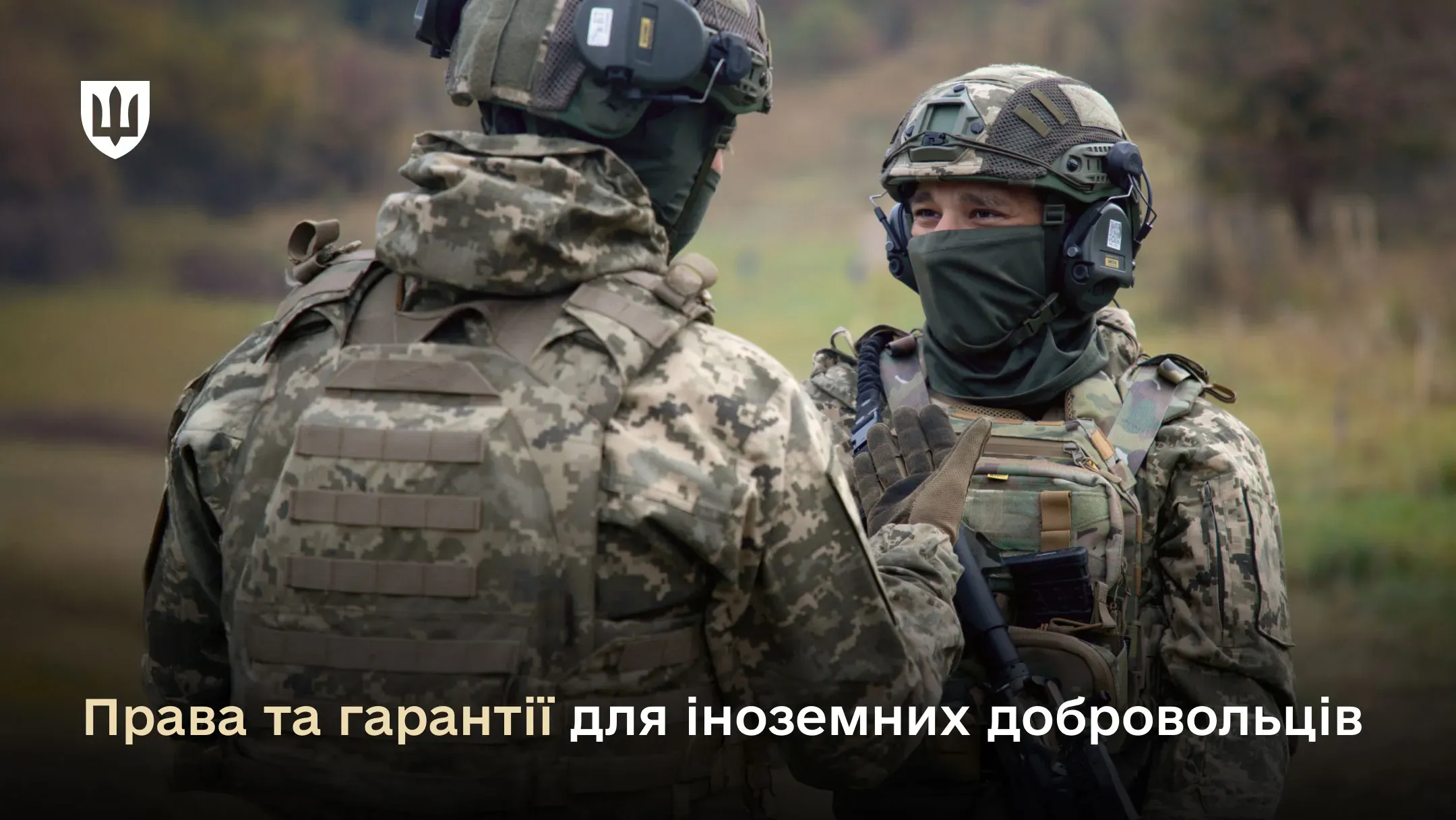 Фото двох військових у повному спорядженні (камуфляж MM-14, шоломи з активними навушниками, бронежилети) на фоні осіннього лісу. Один стоїть спиною, інший — обличчям до нього, у масці-балаклаві. Воїни потискають руки один одному. 