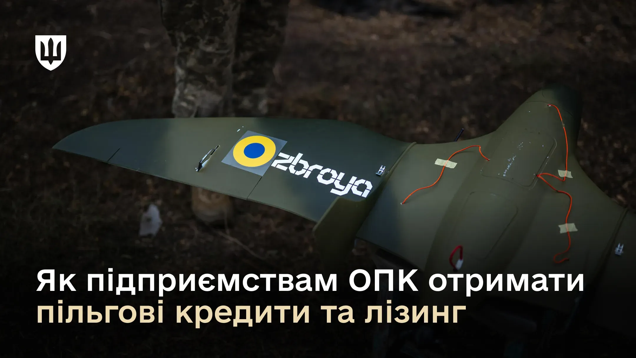 На зображенні показано частину крила військового безпілотника зеленого кольору з логотипом «Obroya» та державною символікою України