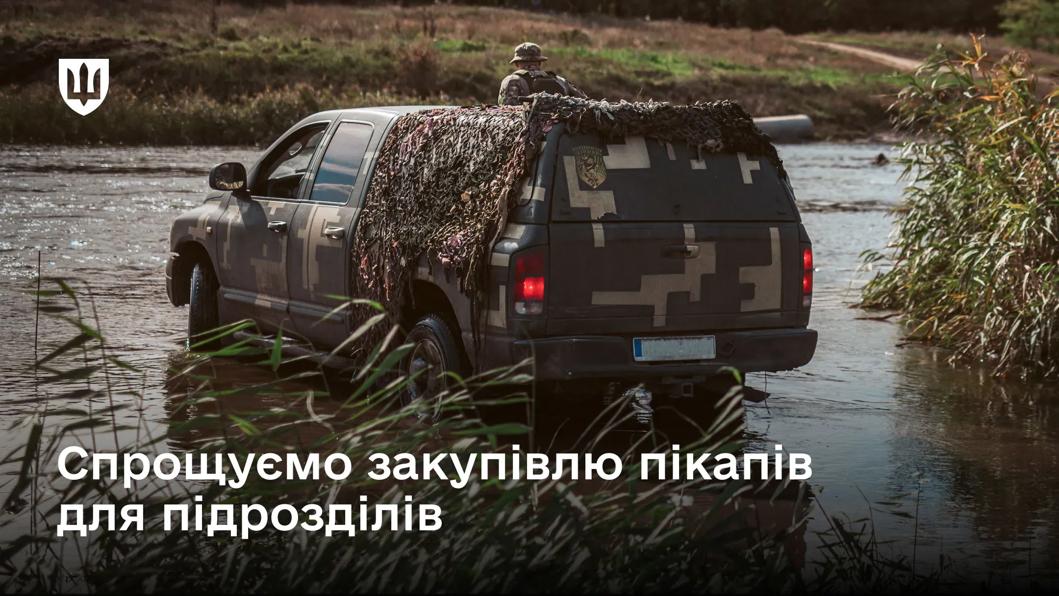 Військовий пікап у камуфляжі перетинає водойму