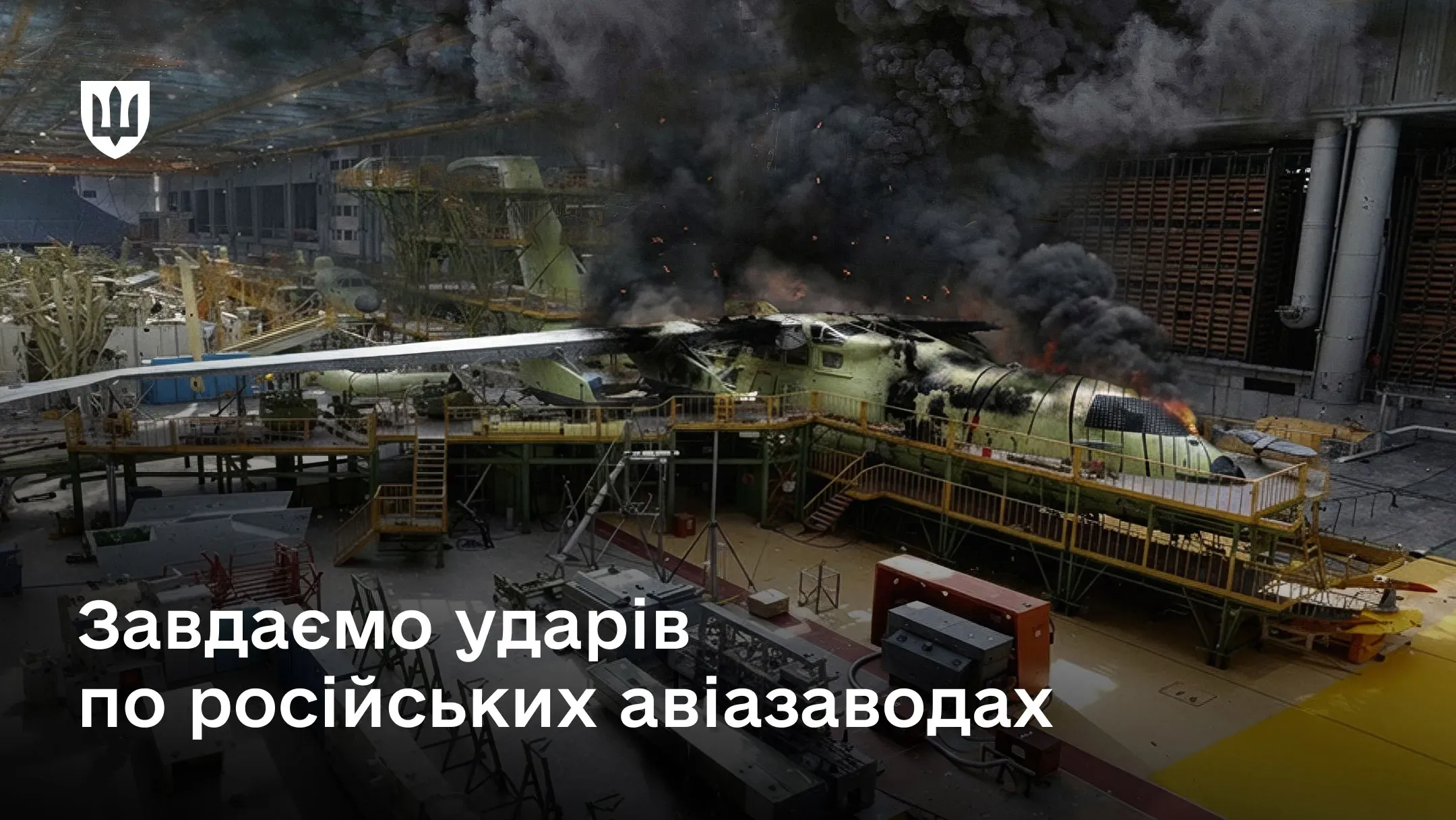 Фото всередині авіаційного заводу, де горить фюзеляж літака на стадії збірки. Приміщення заповнене густим чорним димом