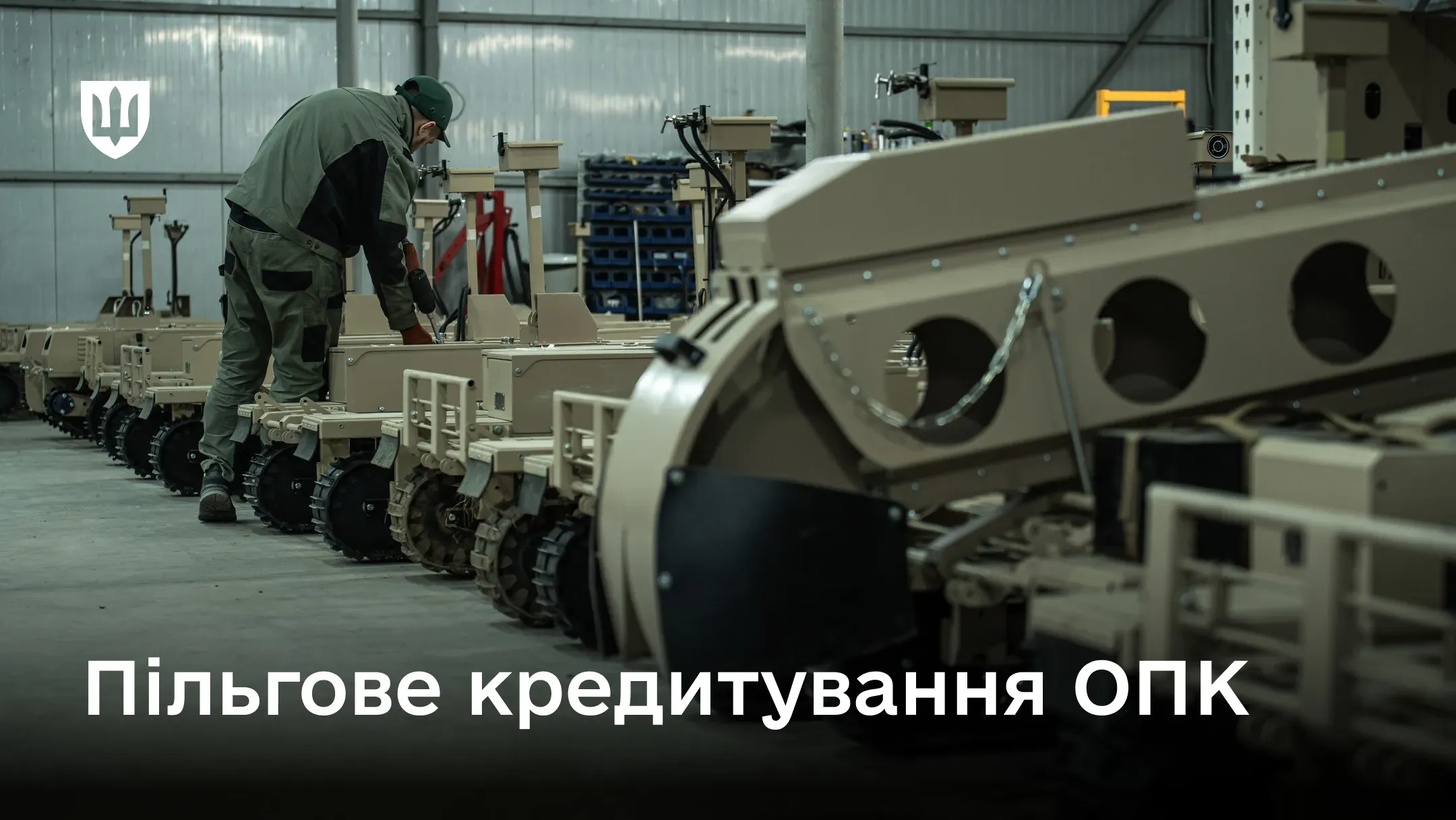 Цех зі збирання гусеничних наземних дронів на фоні напису про пільгове кредитування оборонно-промислового комплексу.