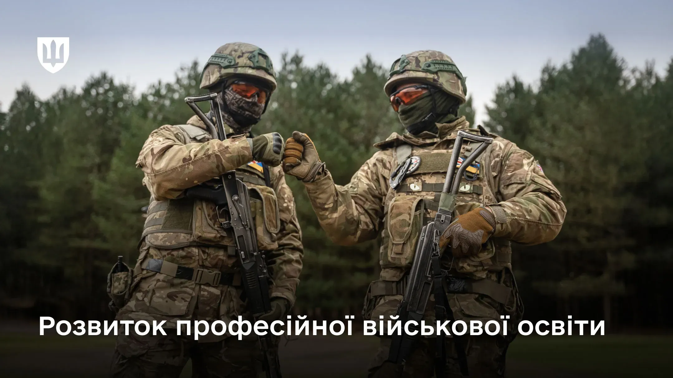 Двоє повністю екіпірованих українських військових роблять дружній жест кулаками на фоні лісу; на зображенні розміщено логотип Міноборони та напис «Розвиток професійної військової освіти»