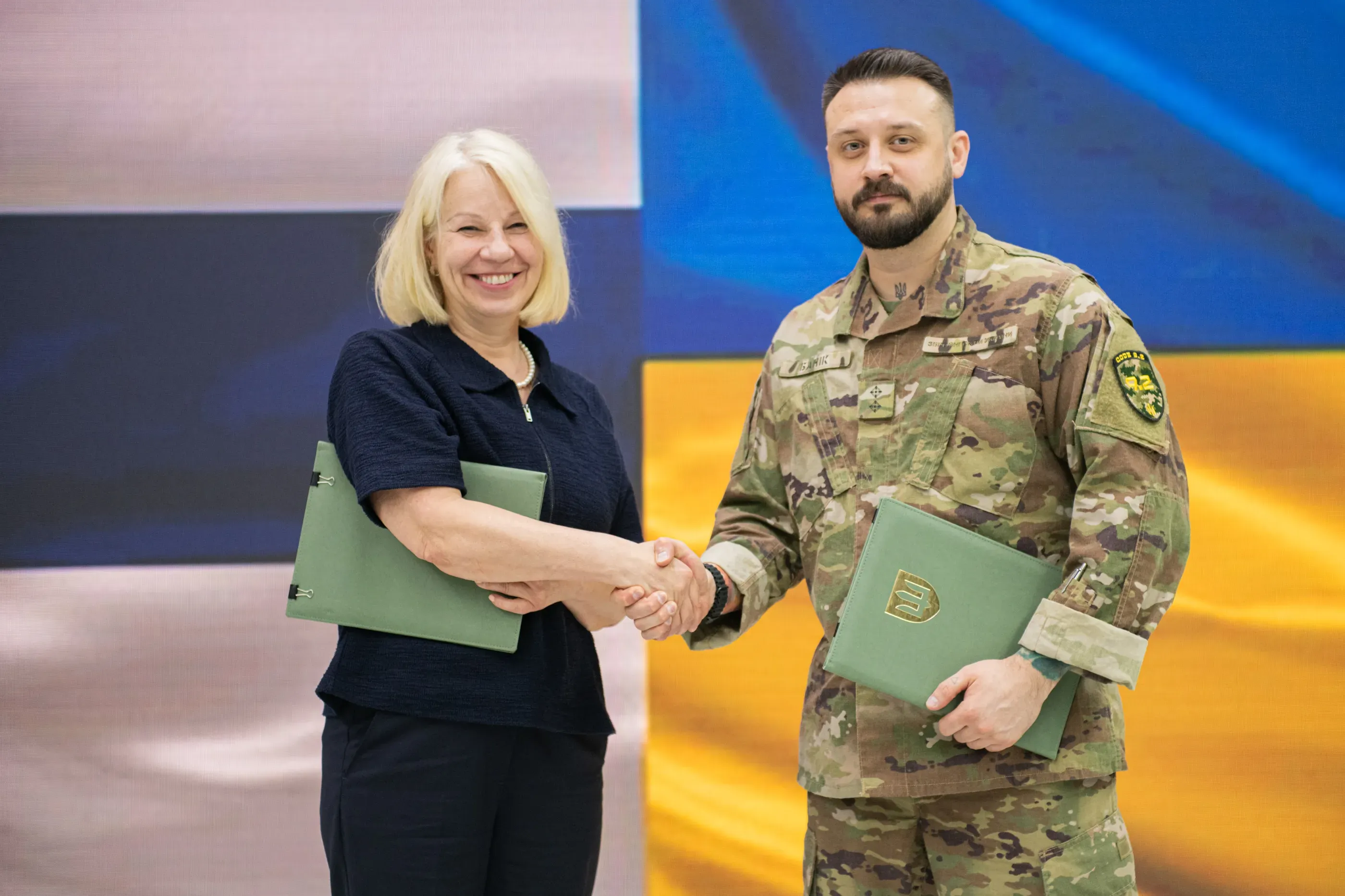 Посол Фінляндії Тар'я Фернандес та заступник Міністра оборони Мстислав Банік посміхаються і тиснуть одне одному руки