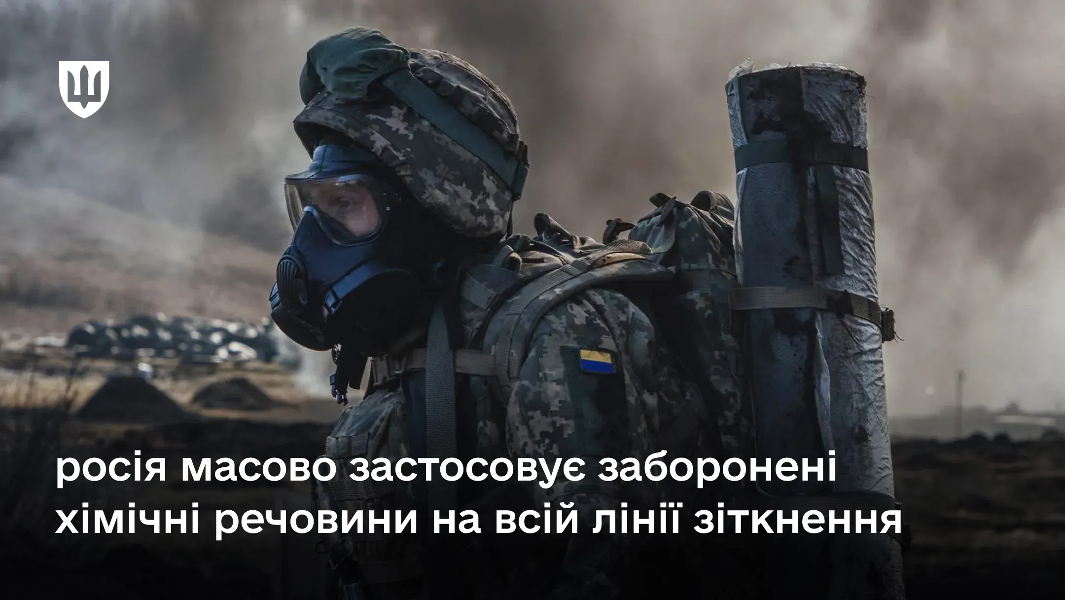 Український військовий в протигазі та повному бойовому спорядженні на тлі задимленого поля бою через те, що росія масово застосовує заборонені хімічні речовини на всій лінії зіткнення