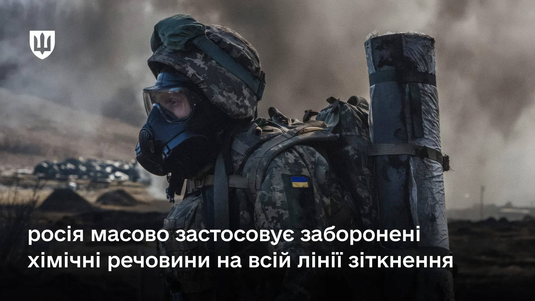 Український військовий в протигазі та повному бойовому спорядженні на тлі задимленого поля бою через те, що росія масово застосовує заборонені хімічні речовини на всій лінії зіткнення