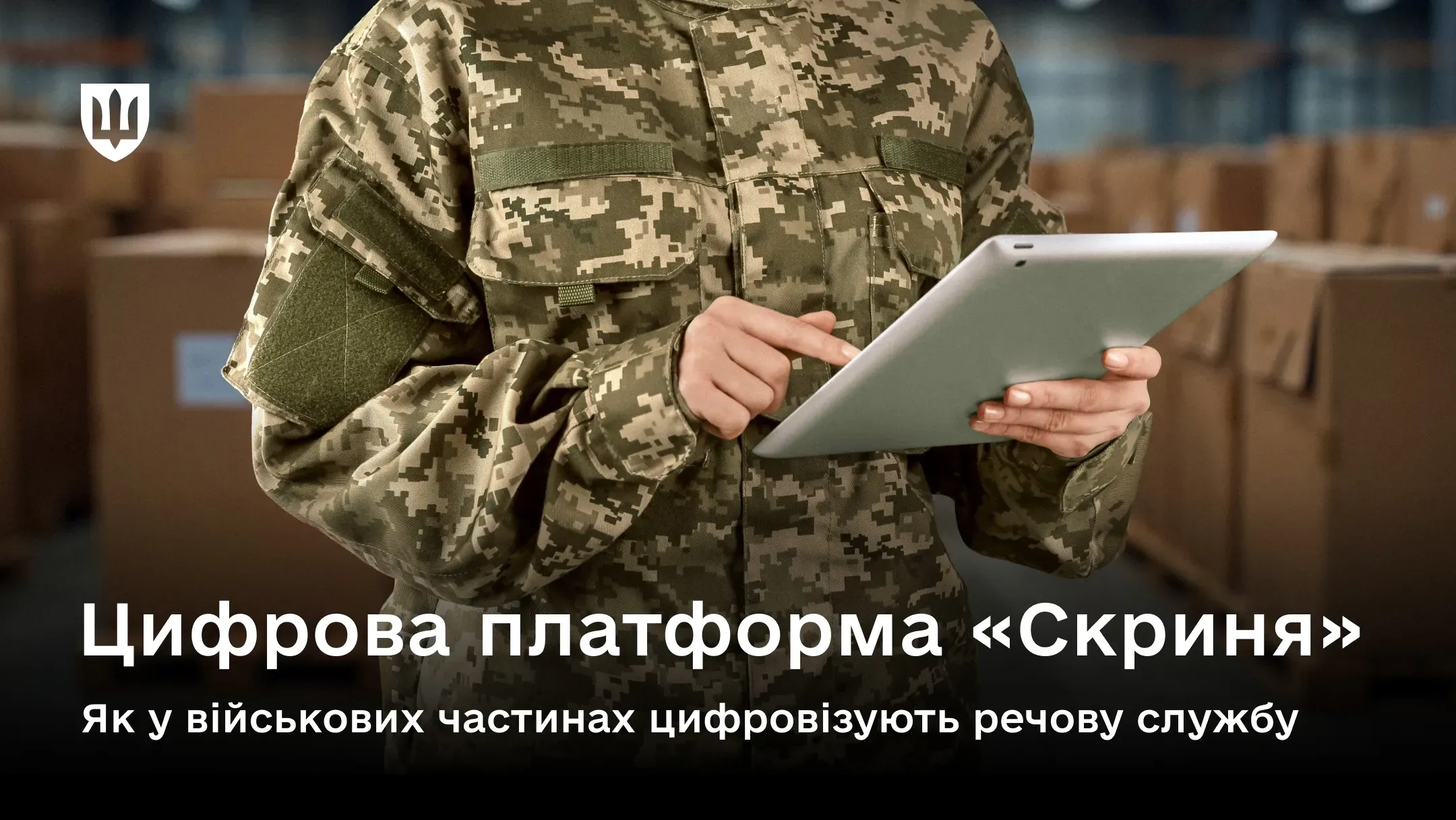Військовослужбовець у камуфляжі тримає планшет і працює з даними на складі серед коробок