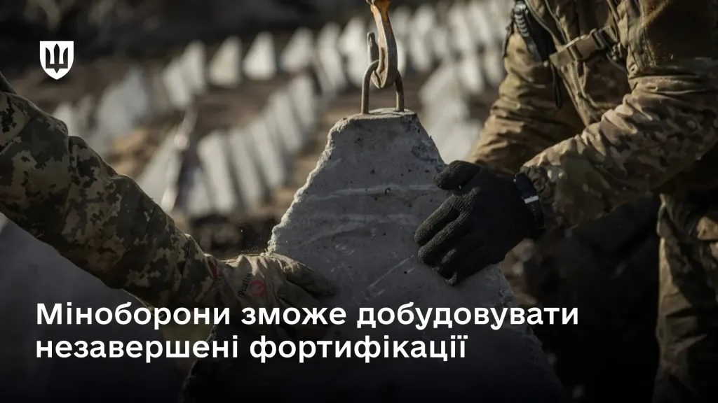 Процес встановлення бетонних захисних споруд українськими військовими, що супроводжується текстом про надання Міноборони повноважень добудовувати незавершені фортифікації