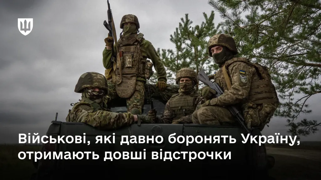 Чотири українські військовослужбовці у повному екіпіруванні та зі зброєю перебувають у кузові автомобіля на тлі похмурого неба та сосен