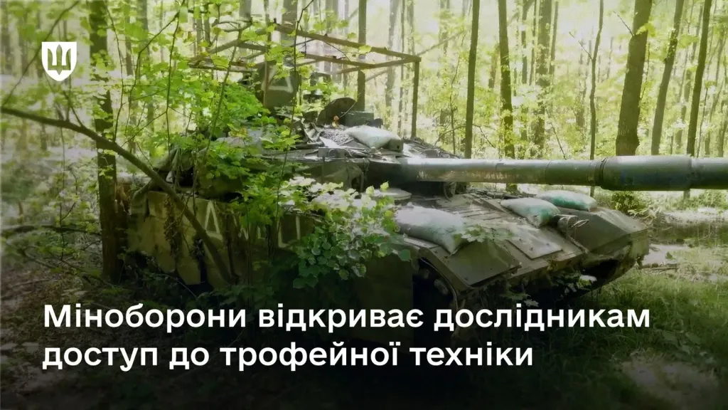 Закамуфльований танк із захисним навісом у лісовій місцевості