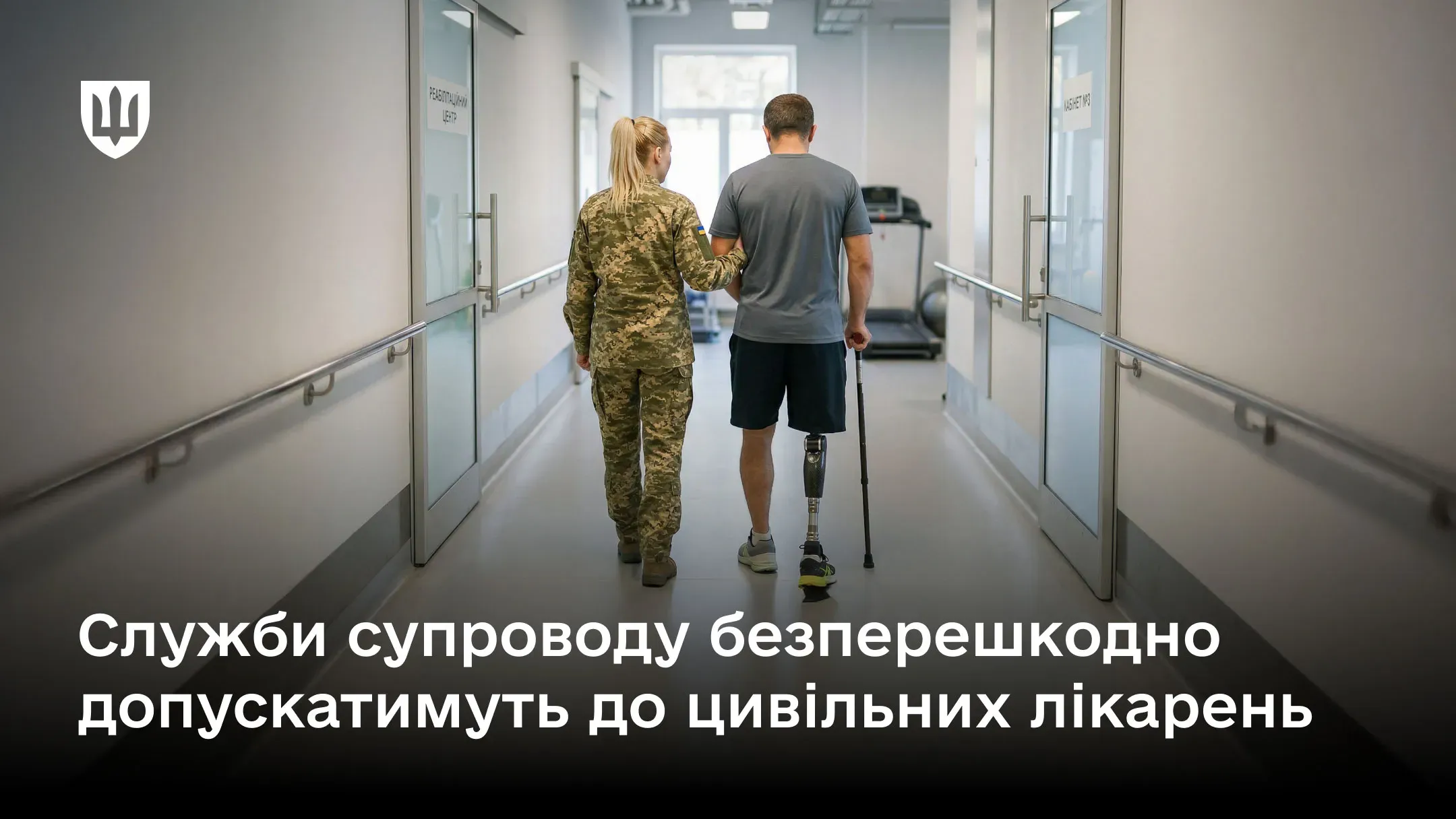 Військовослужбовиця супроводжує чоловіка з протезом ноги та милицею коридором лікарні